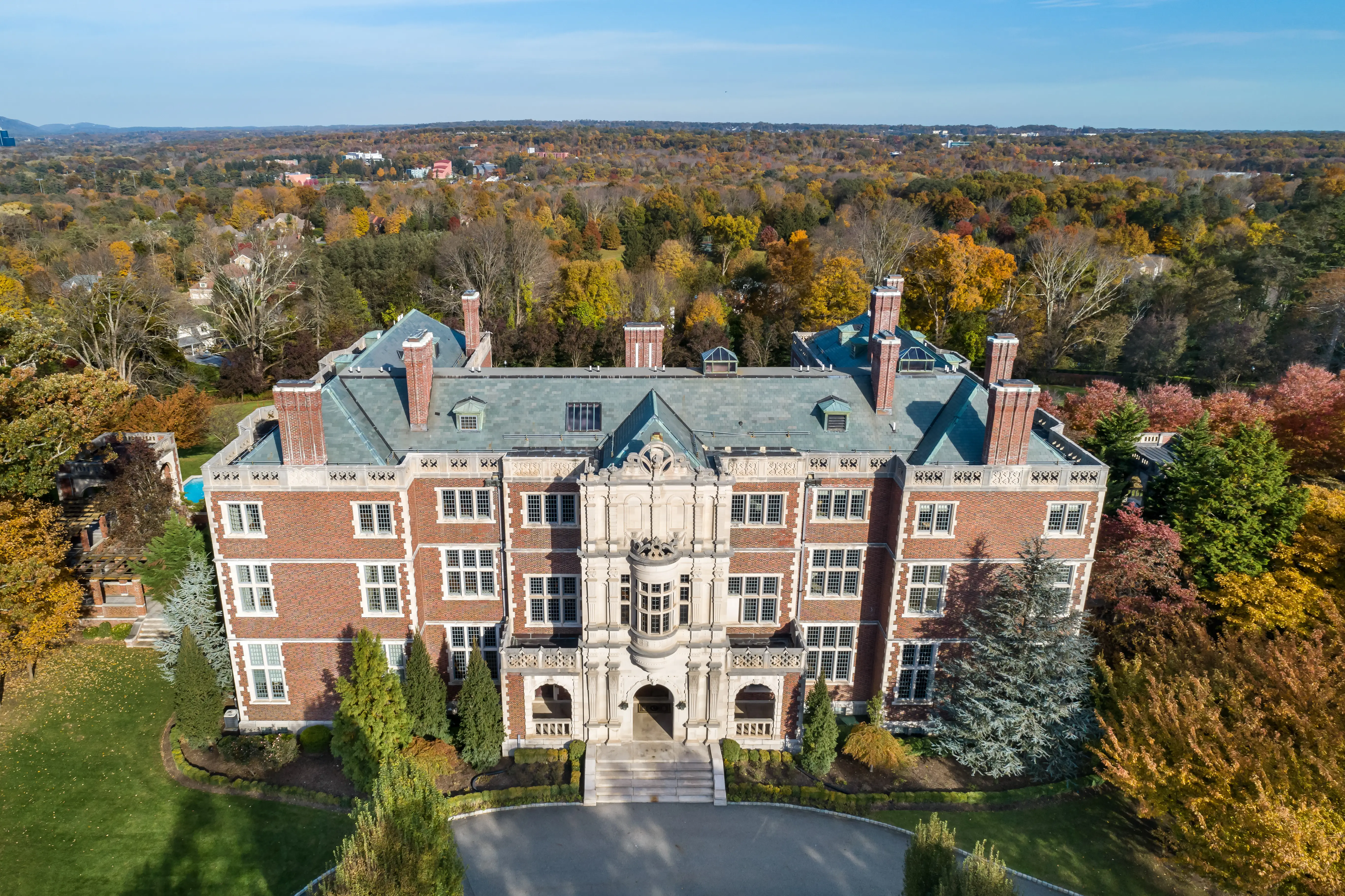 This photo shows the brick and carved-limestone front exterior and the grounds of the 1907 Crocker-McMillin mansion in Mahwah, New Jersey.