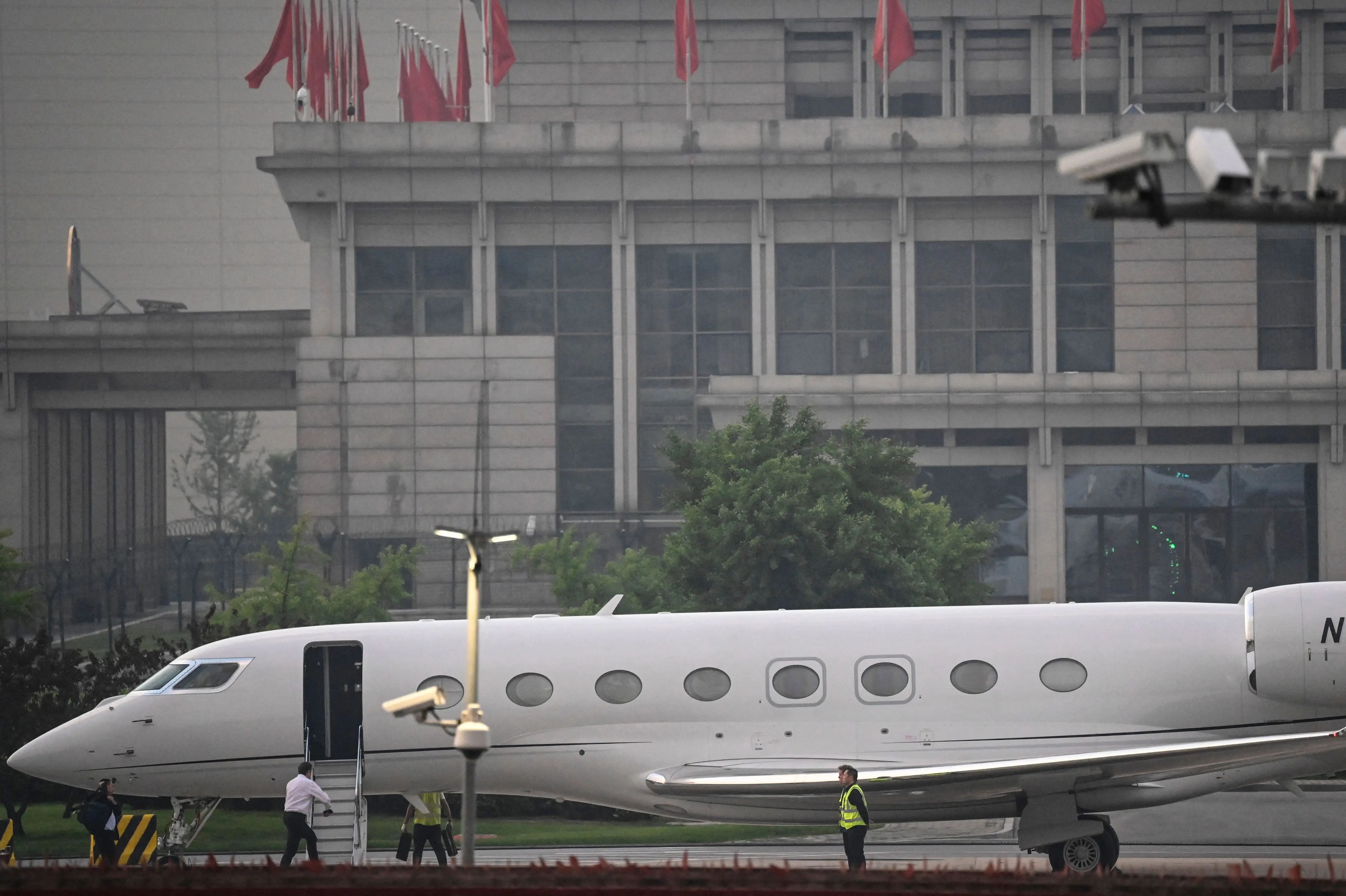 Tesla Chief Executive Officer Elon Musk (in white) boards his private jet before departing from Beijing Capital International Airport on May 31, 2023.