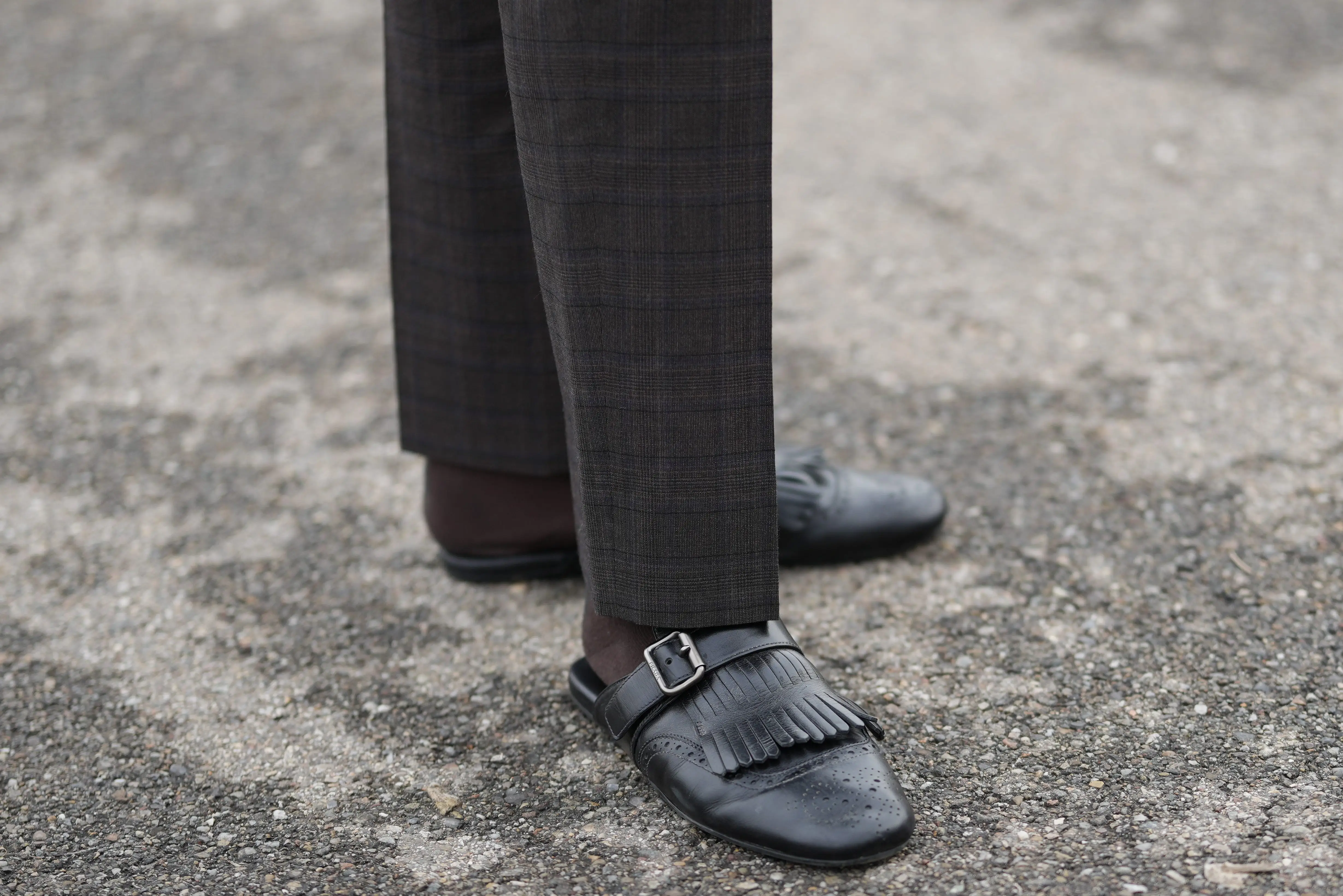 Black slip-on backless loafers with socks and plaid pants