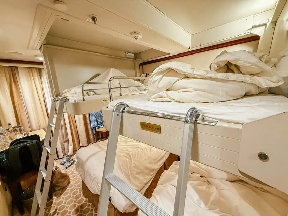 Beds from ceiling with ladders leading up to them