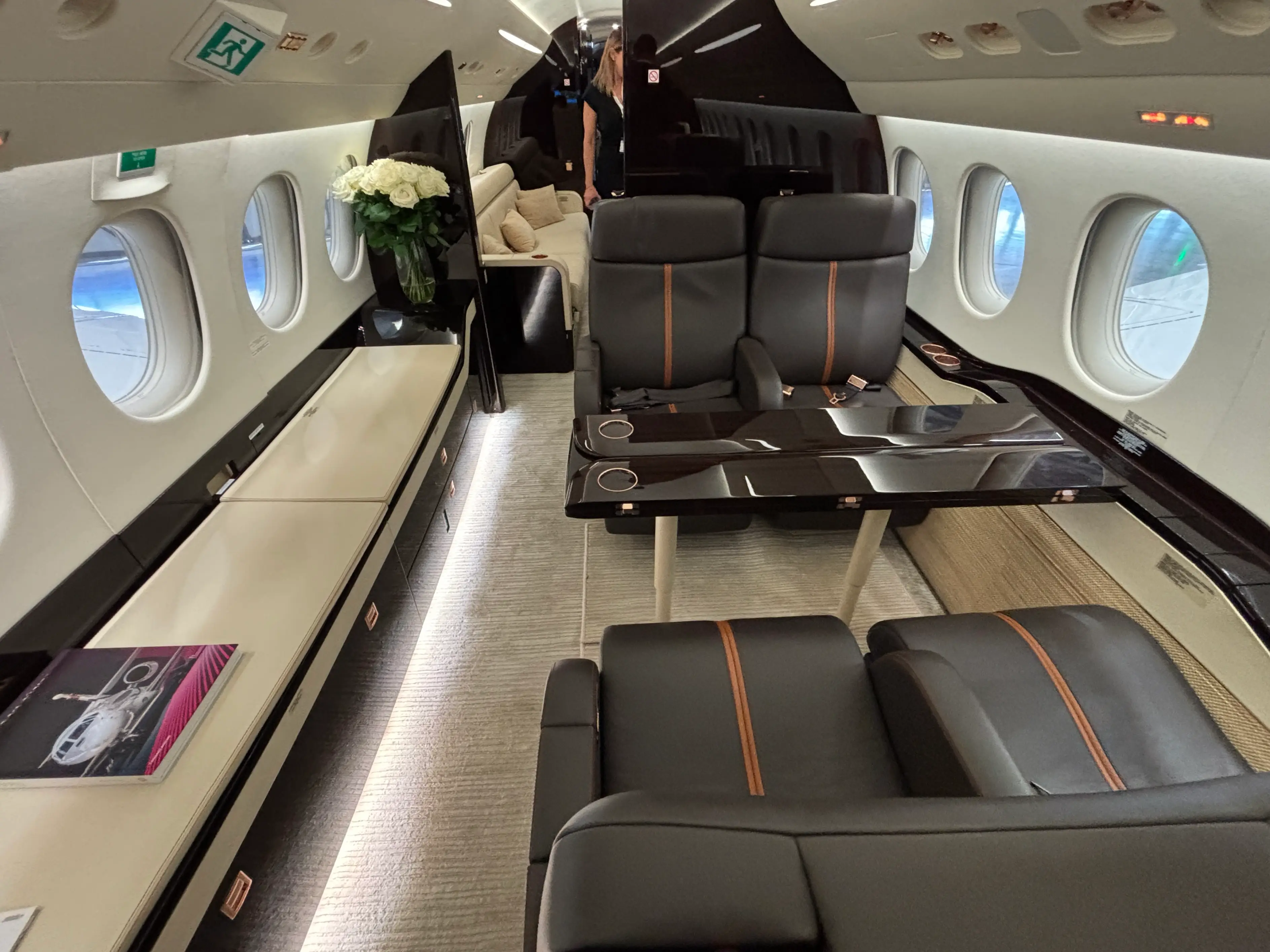 The interior of a Dassault Falcon 8X with four seats and a couch in the background, as pictured at an air show in 2025.