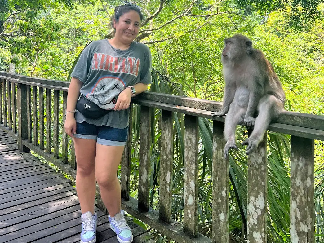 Gabby stands next to a monkey on a bridge in Bali.