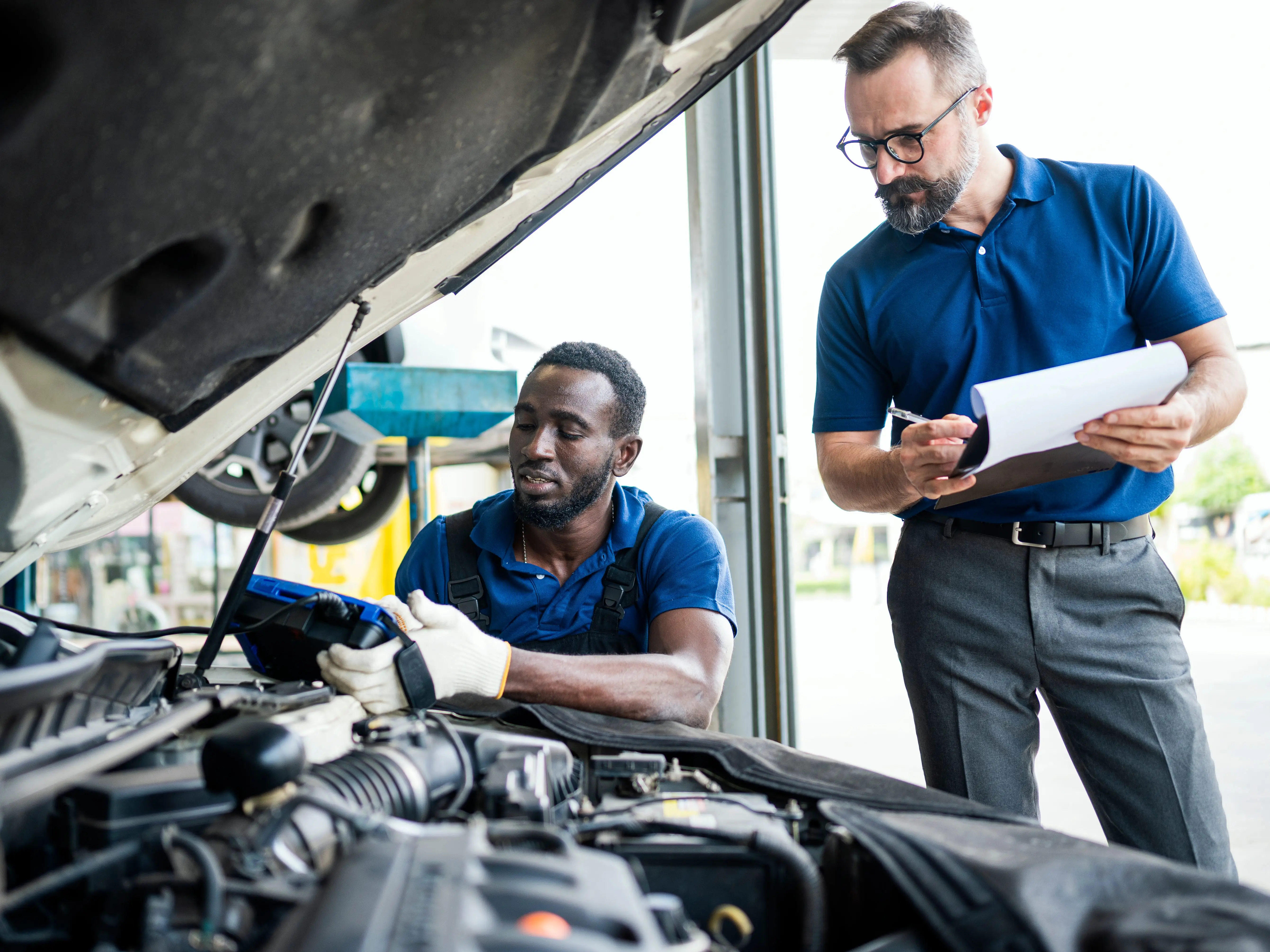 Manager and technician with a vehicle