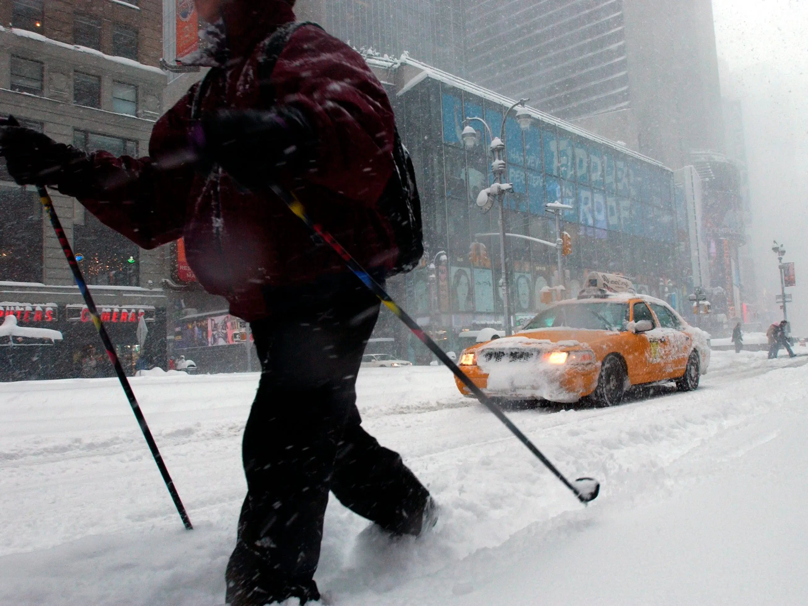 A man on skis make his way through Times Square in a heavy blizzard, in New York City.