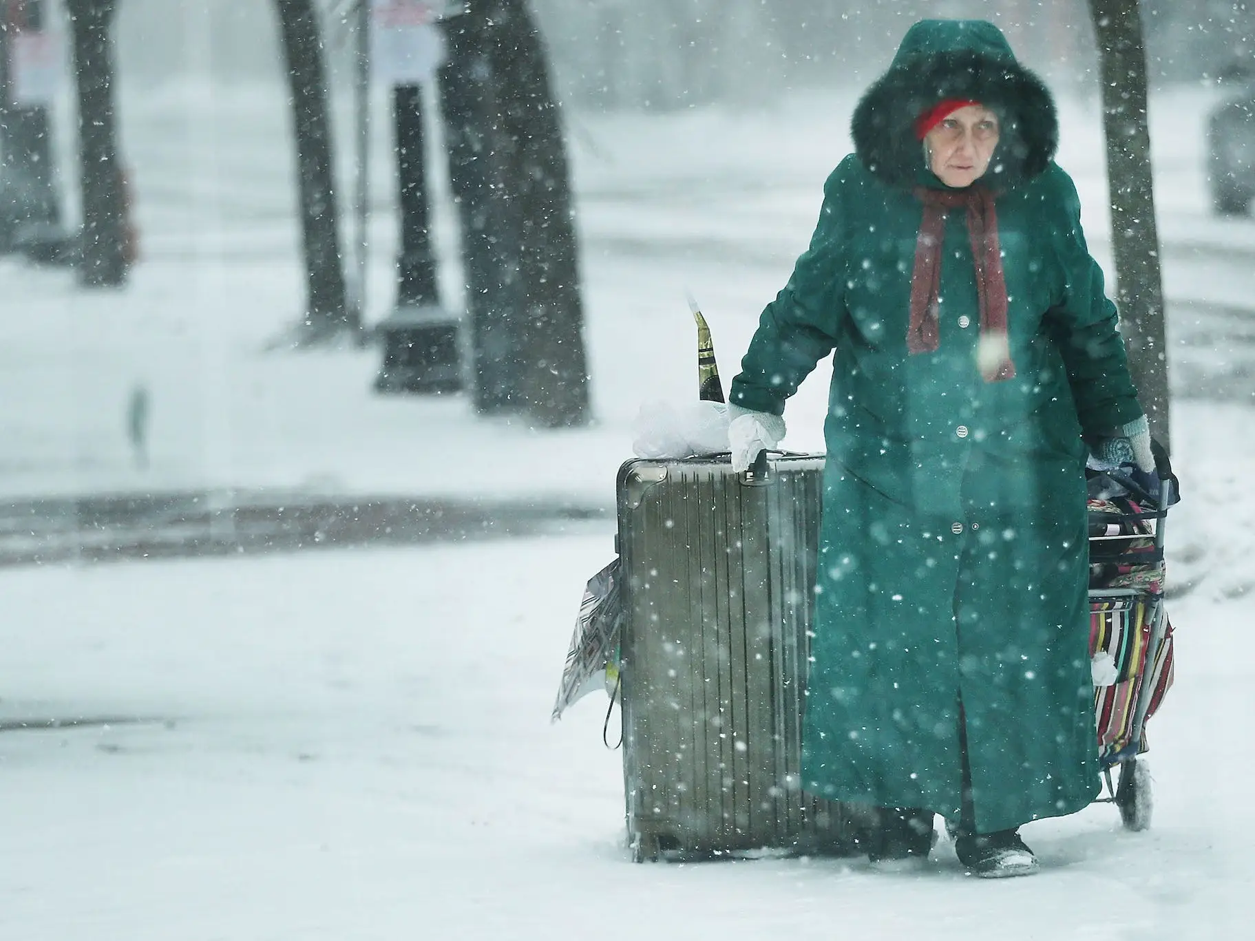 A woman struggles with bags as she walks through the empty streets of Boston as the snow begins to fall from a massive winter storm on January 4, 2018 in Boston, Massachusetts.