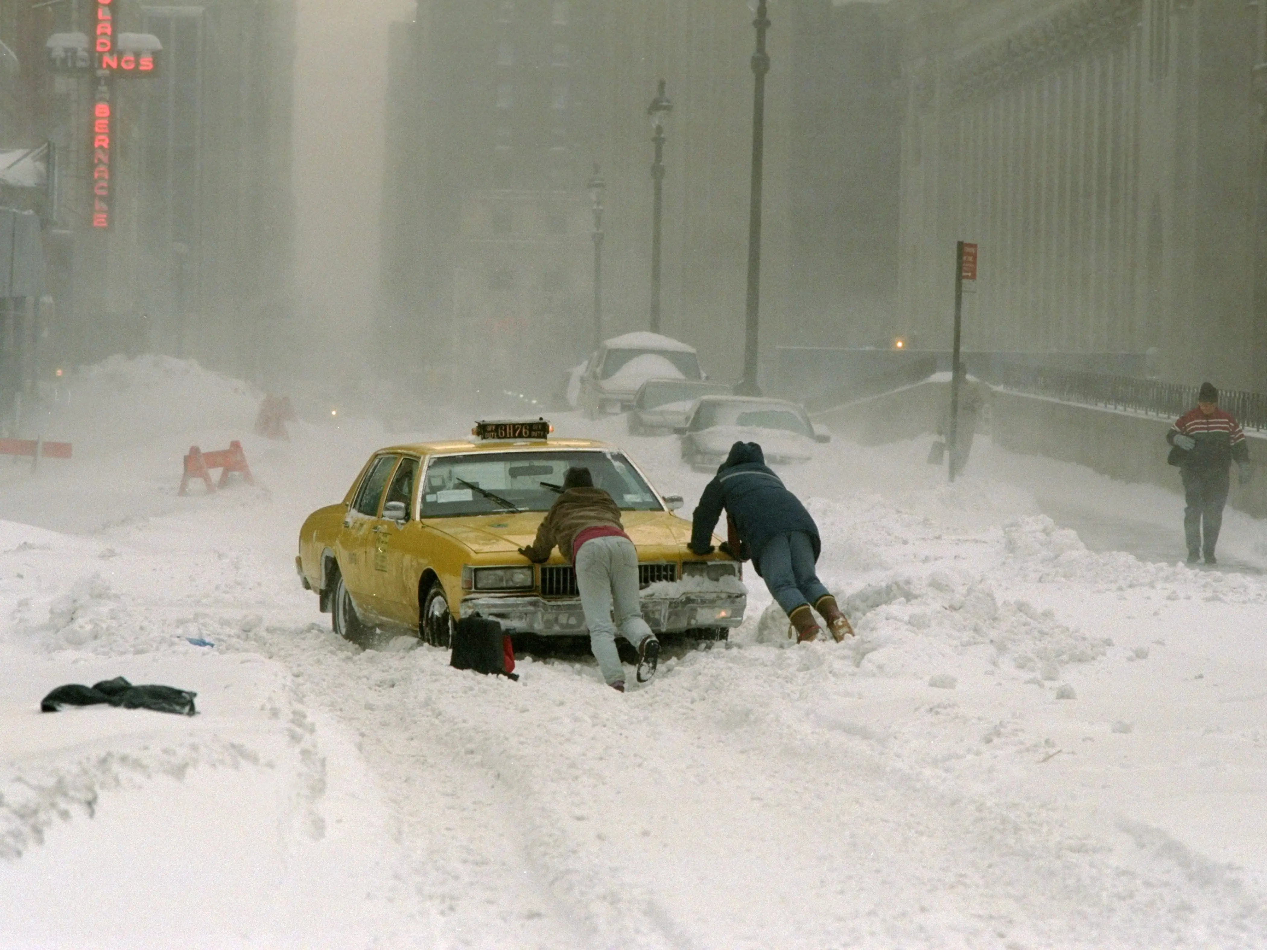 Cab driver pushes his taxi cab after getting stuck on 33rd St. near Ninth Ave. after a blizzard.