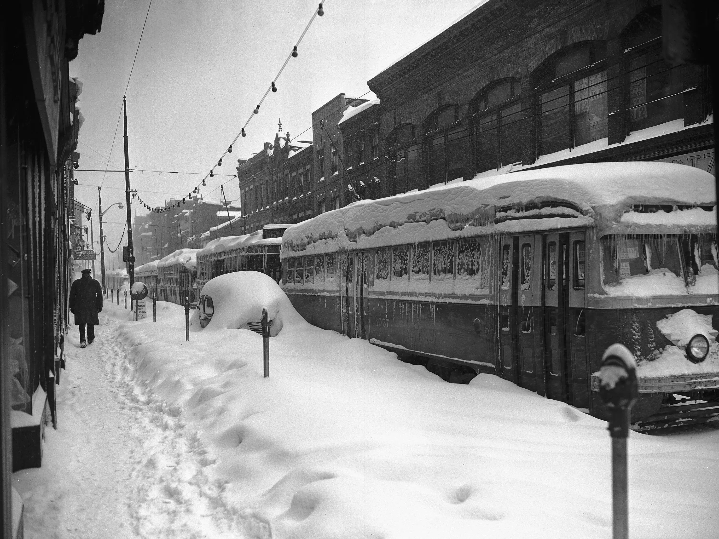 Fifteen street cars are lined up and out of service on Carson Street in Pittsburgh, Pa., November 26, 1950 due to this Winter snow storm. These trolleys have been stalled for several days. Operators gathered in one of the cars to play cards for a time but finally gave up and walked home.