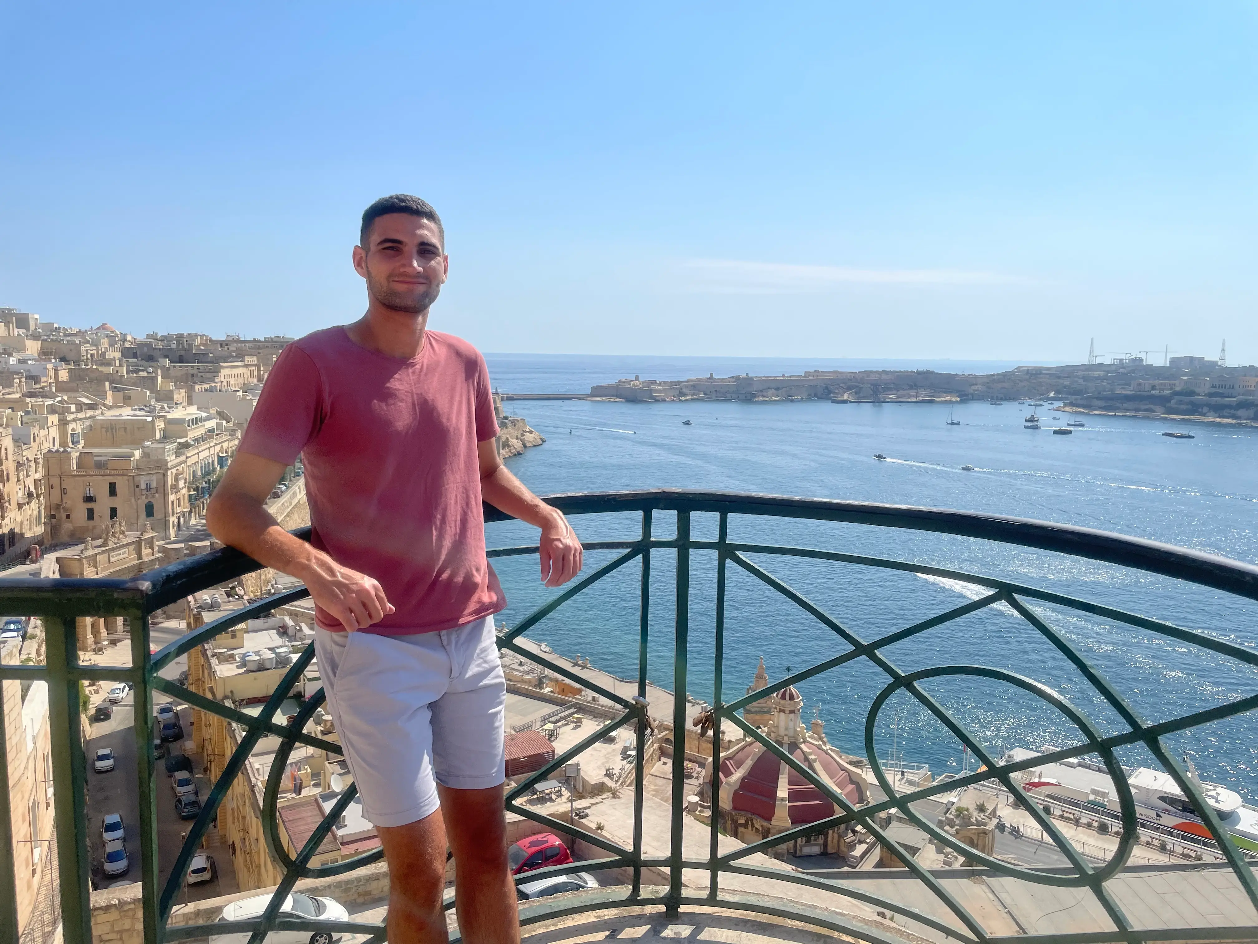 A man standing with the sea in the background in Valletta, Malta.