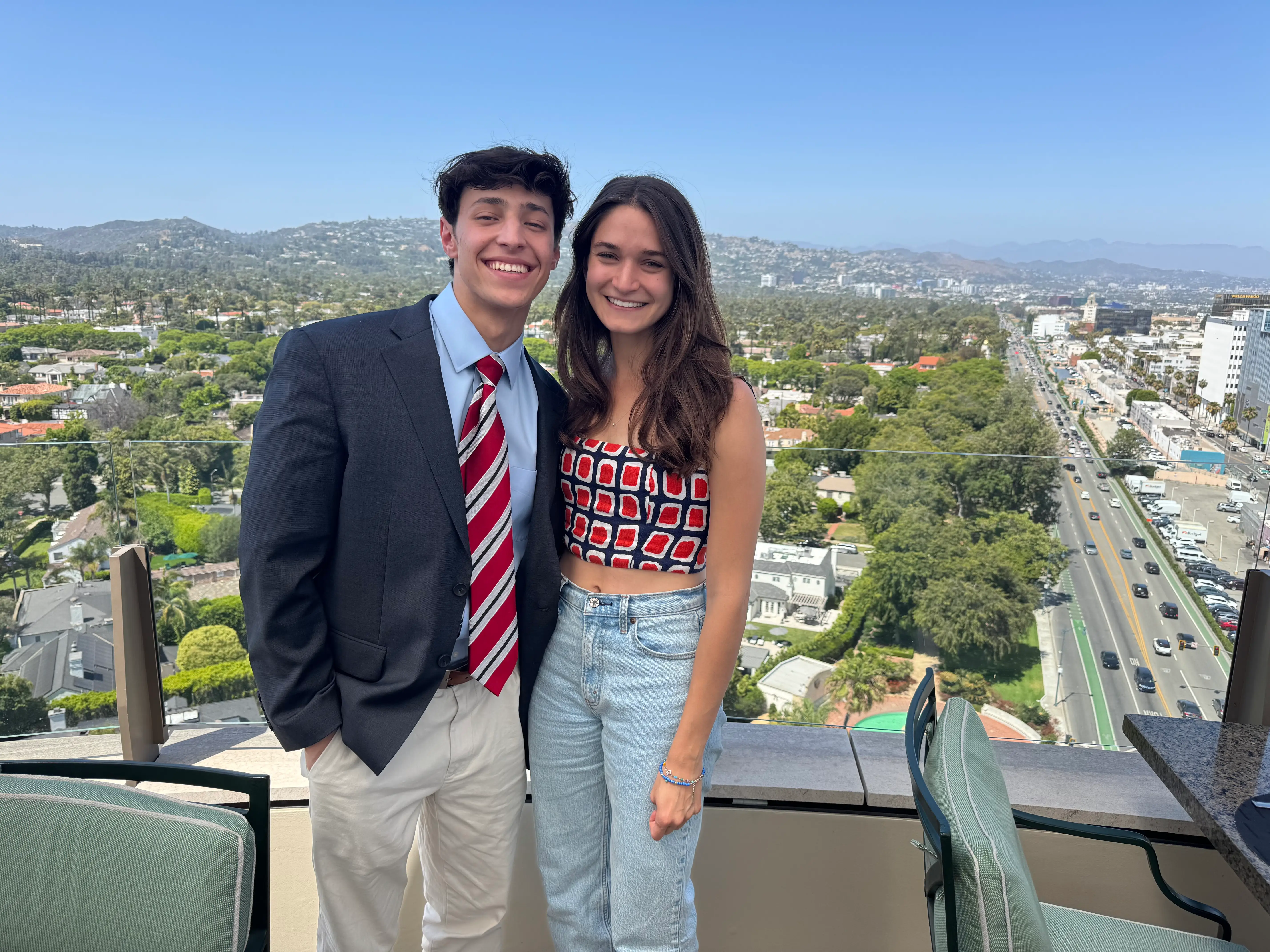 Anna and her brother stand at the edge of a rooftop restaurant in Beverly Hills.