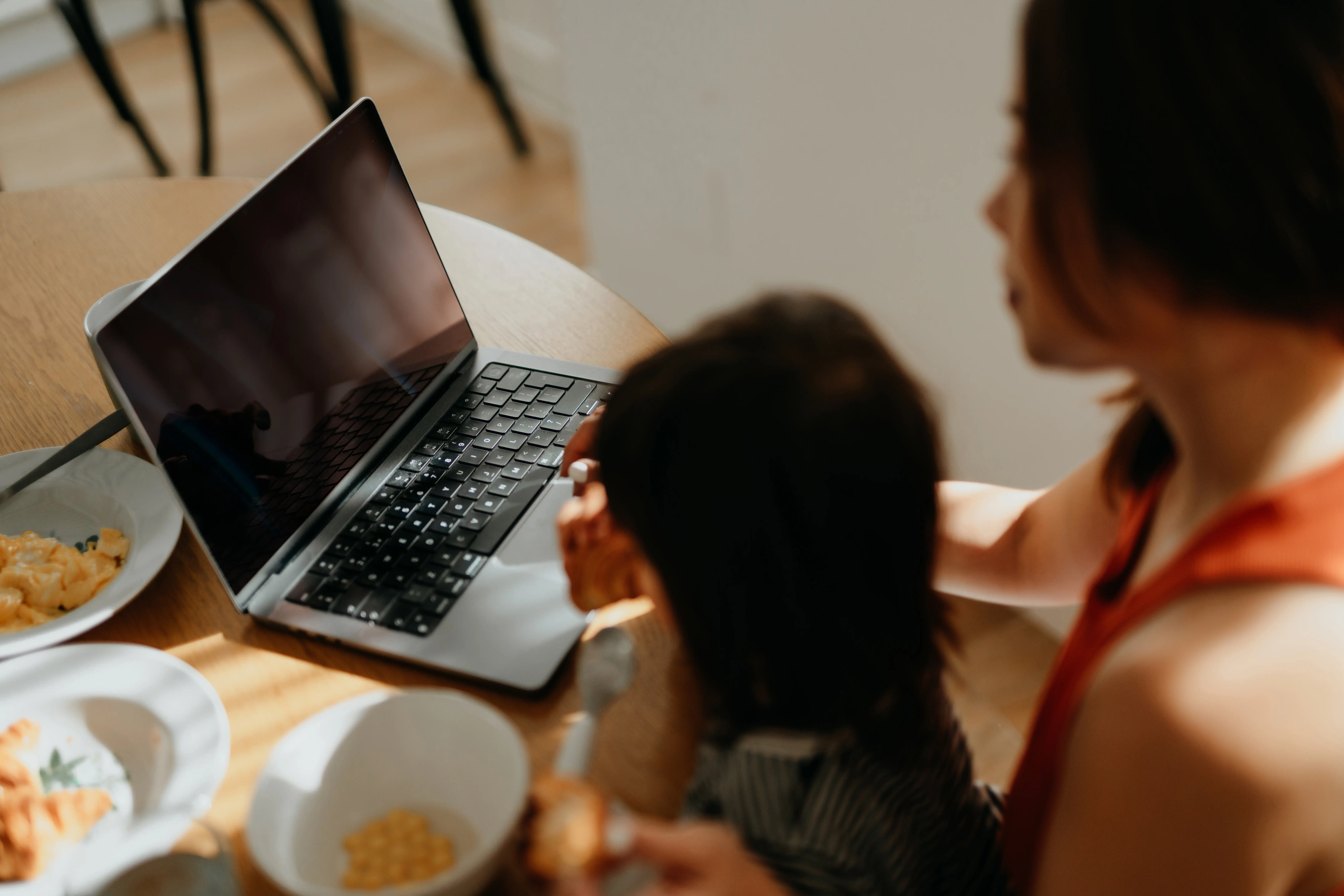 Young mother working from home while taking care of her little girl