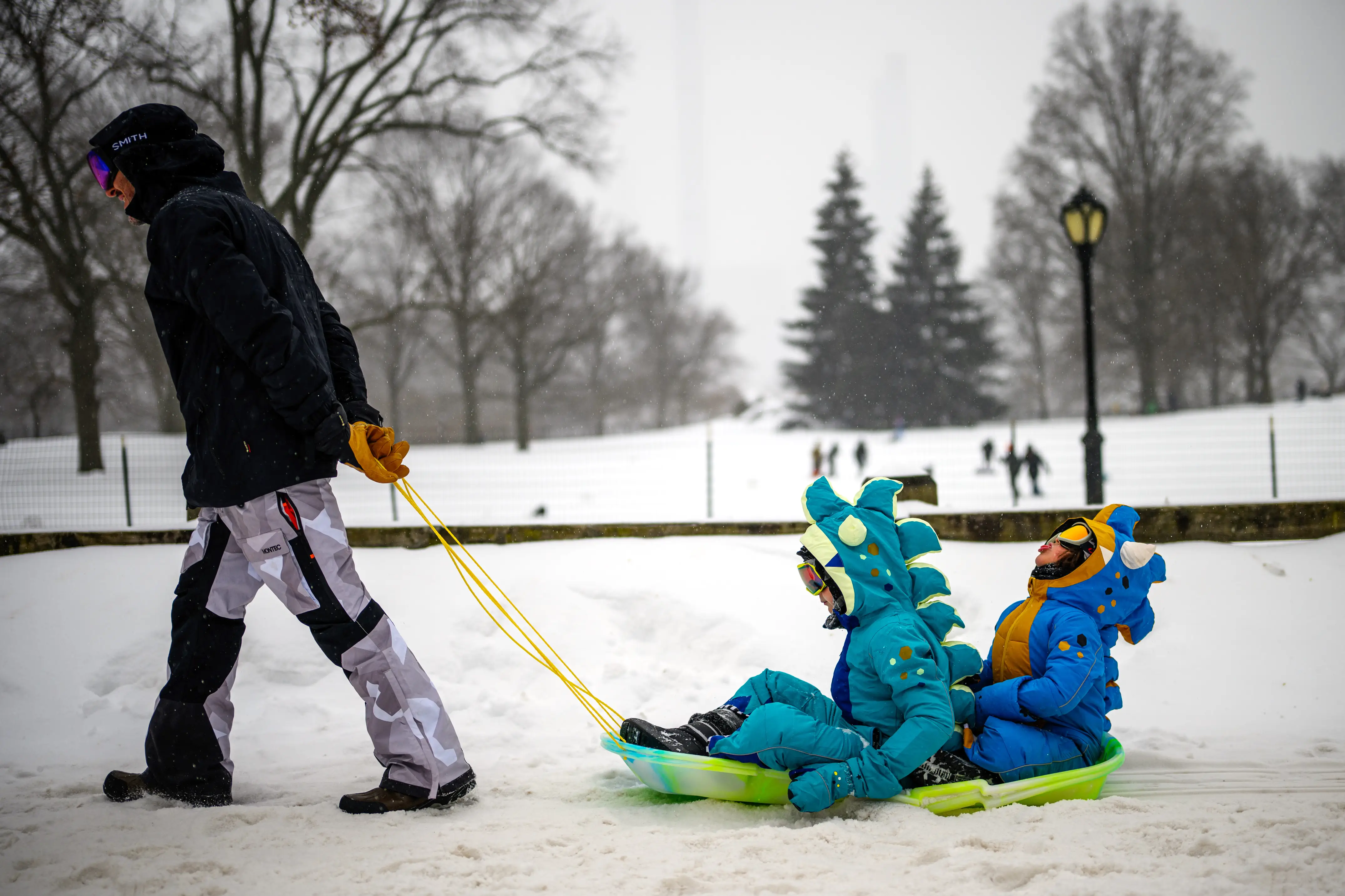 Kids and parents play in the snow.