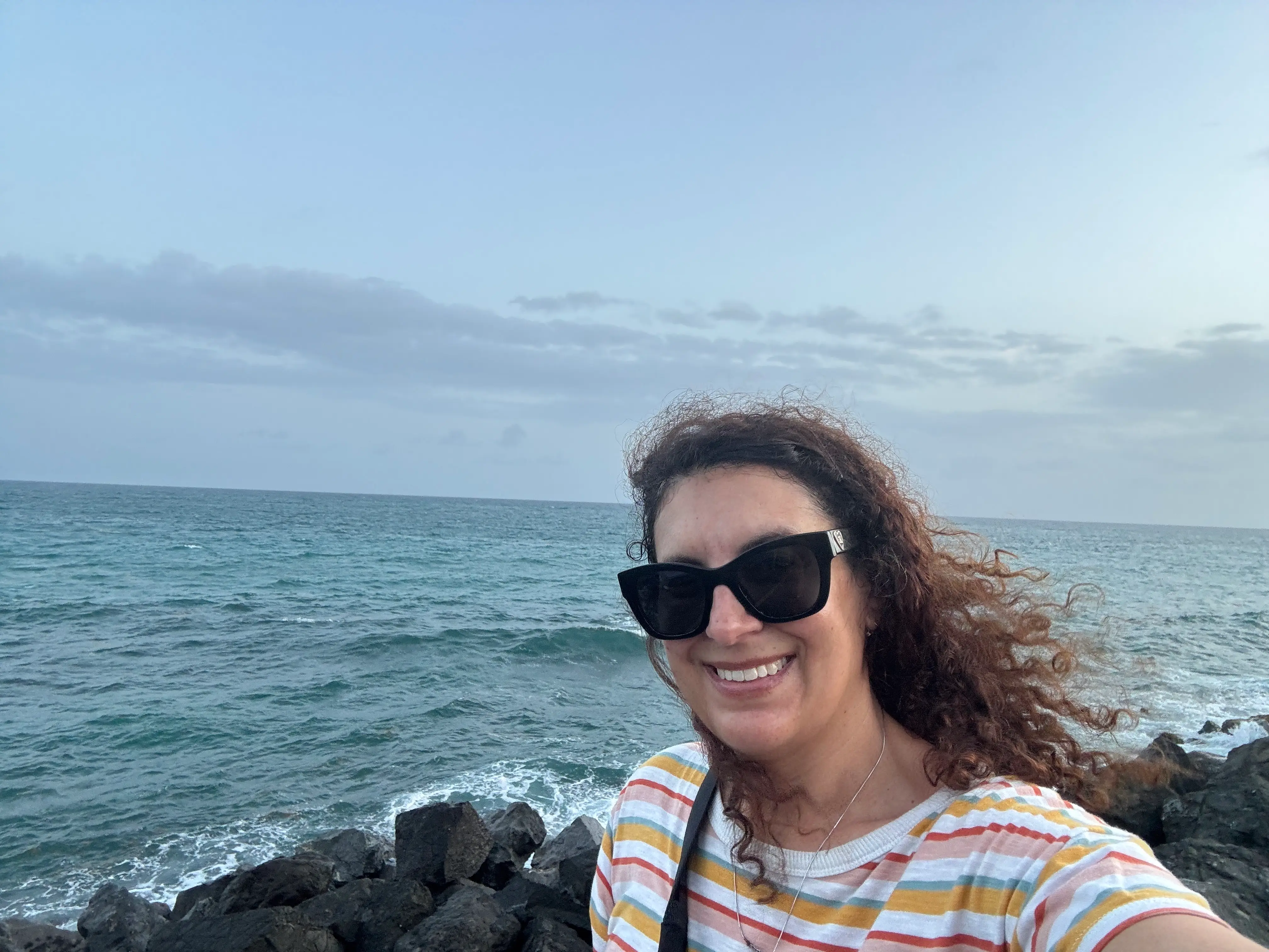 Author Jamie Davis Smith smiling in front of water