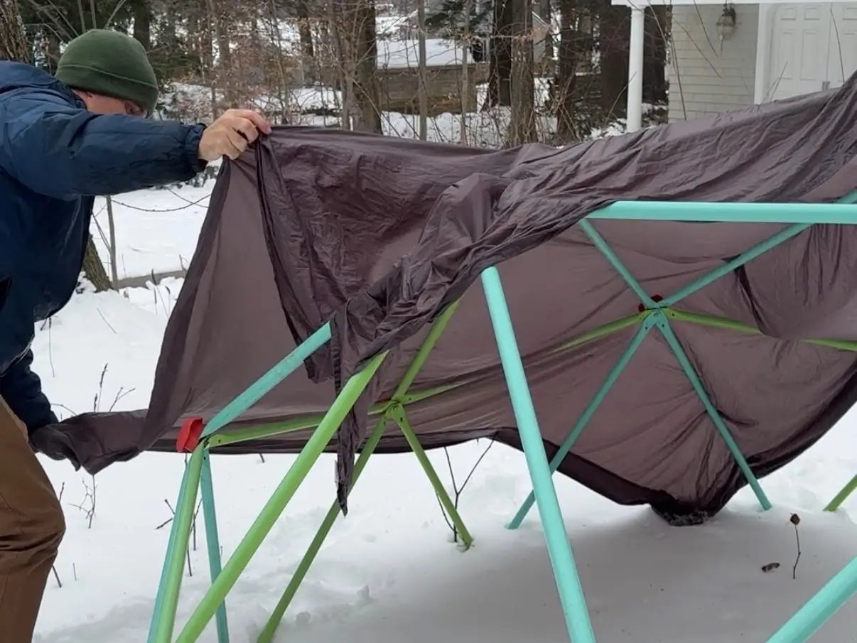 Man covering structure with a sheet