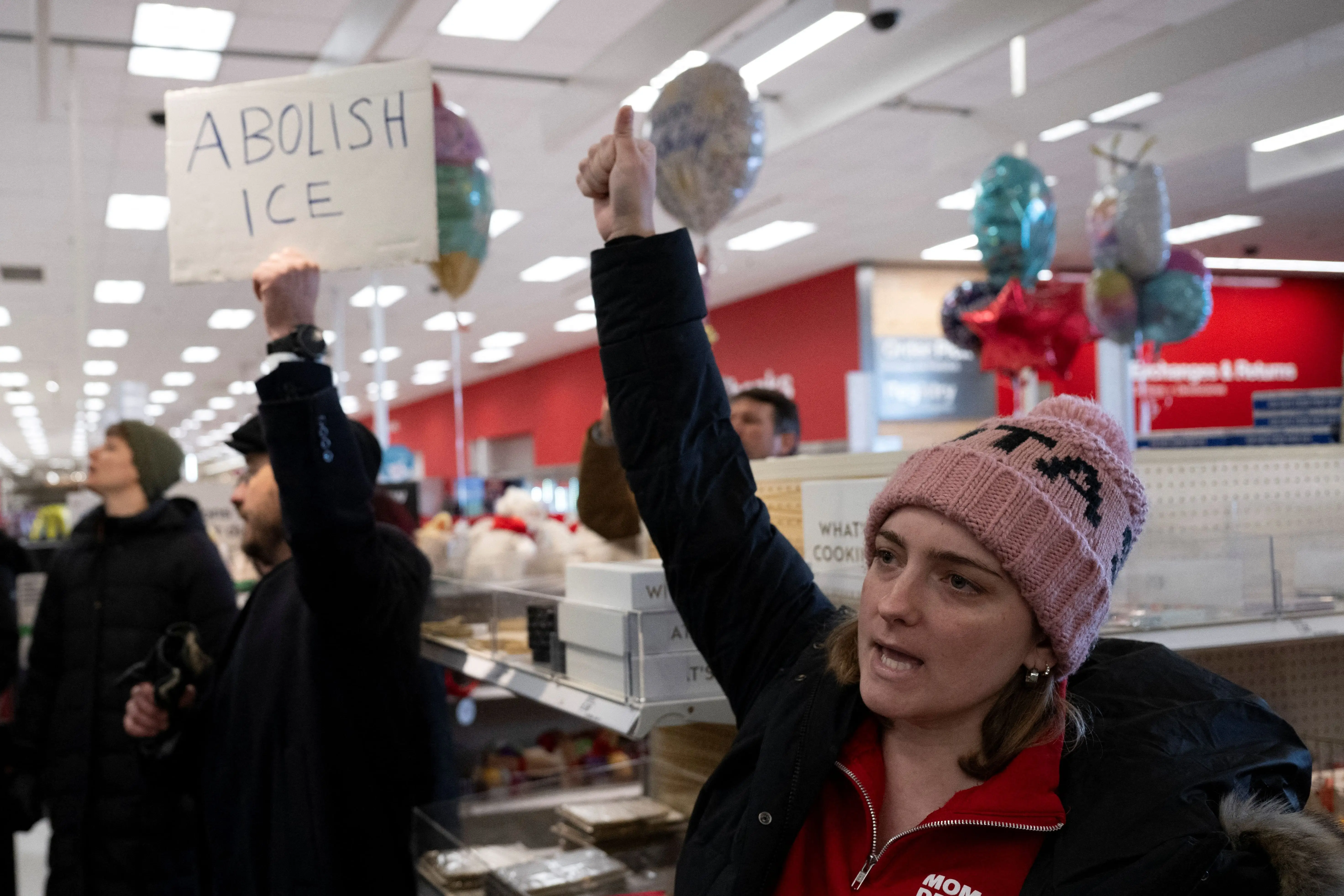 A small crowd of protesters sing along during a sit-in in a Target store as they denounce what they say is complicity by the store to allow Immigration and Customs Enforcement (ICE) agents to come into the store and stage in their parking lot in Saint Paul, Minnesota, on January 19, 2026.