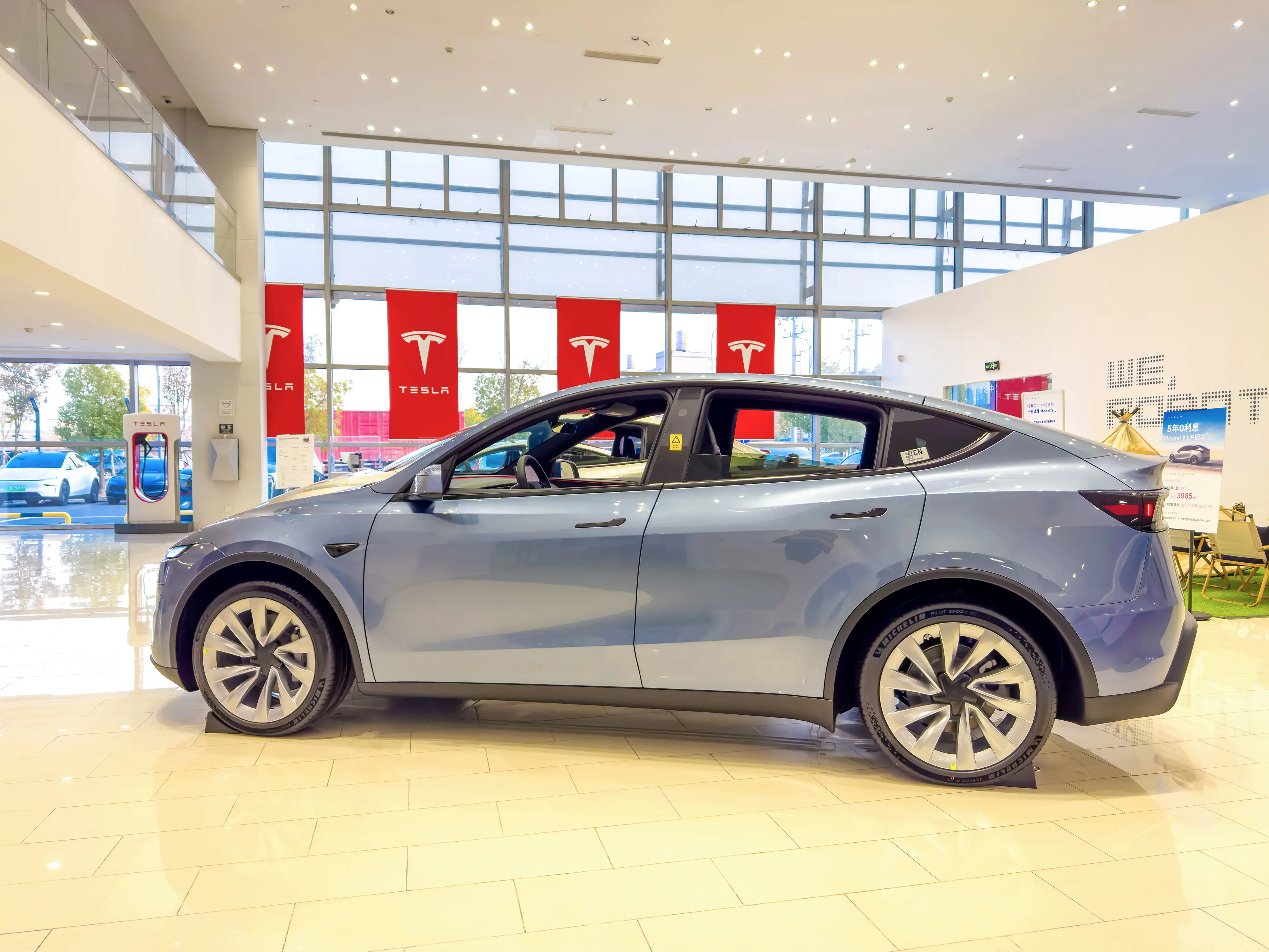 A 202 model is displayed in the Tesla Center showroom