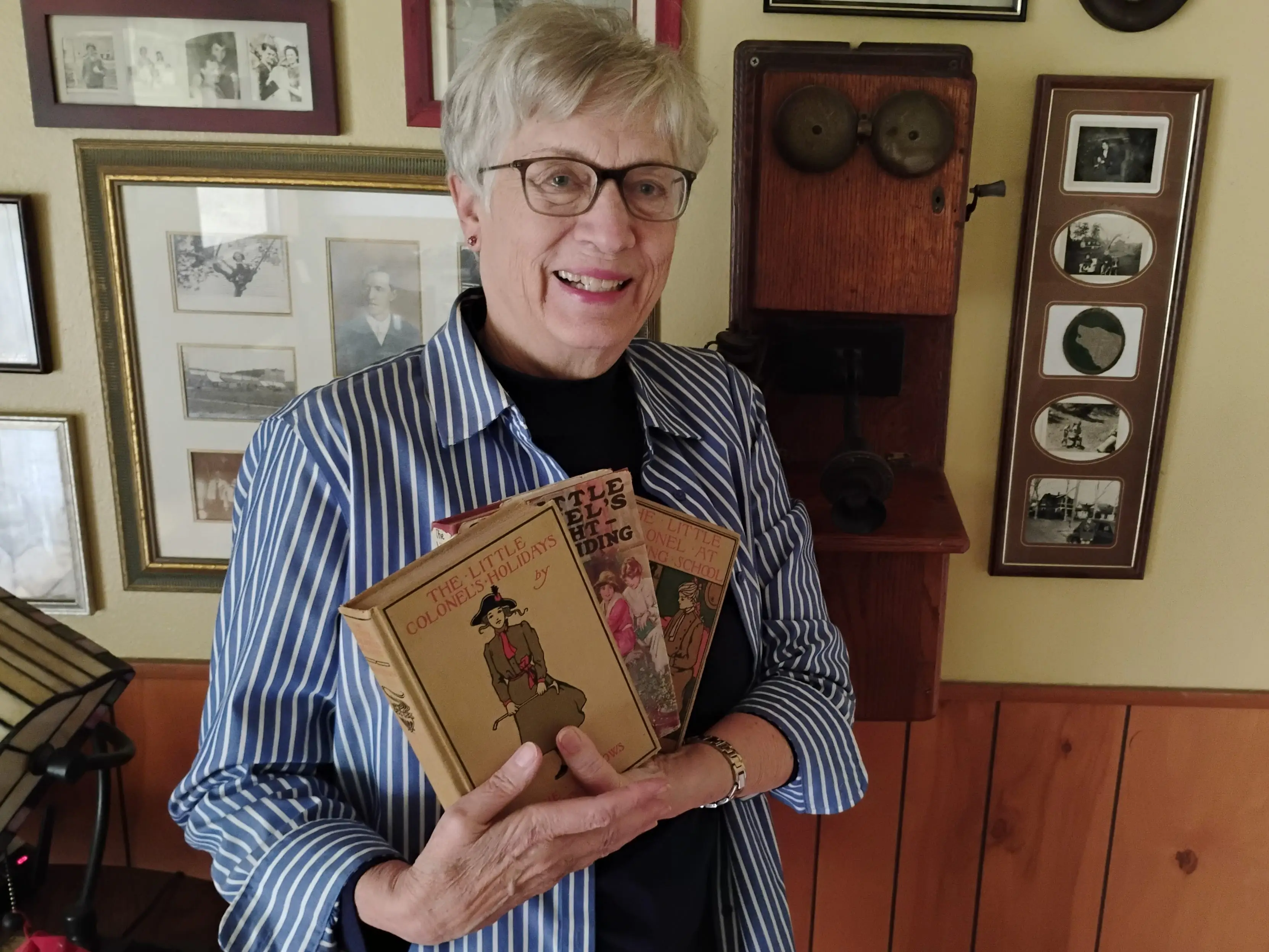 Cynthia Wall holding up her books while decluttering her house