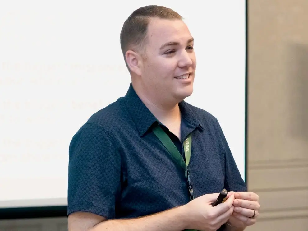 Kyle Elliott standing in front of a projector screen giving a talk.