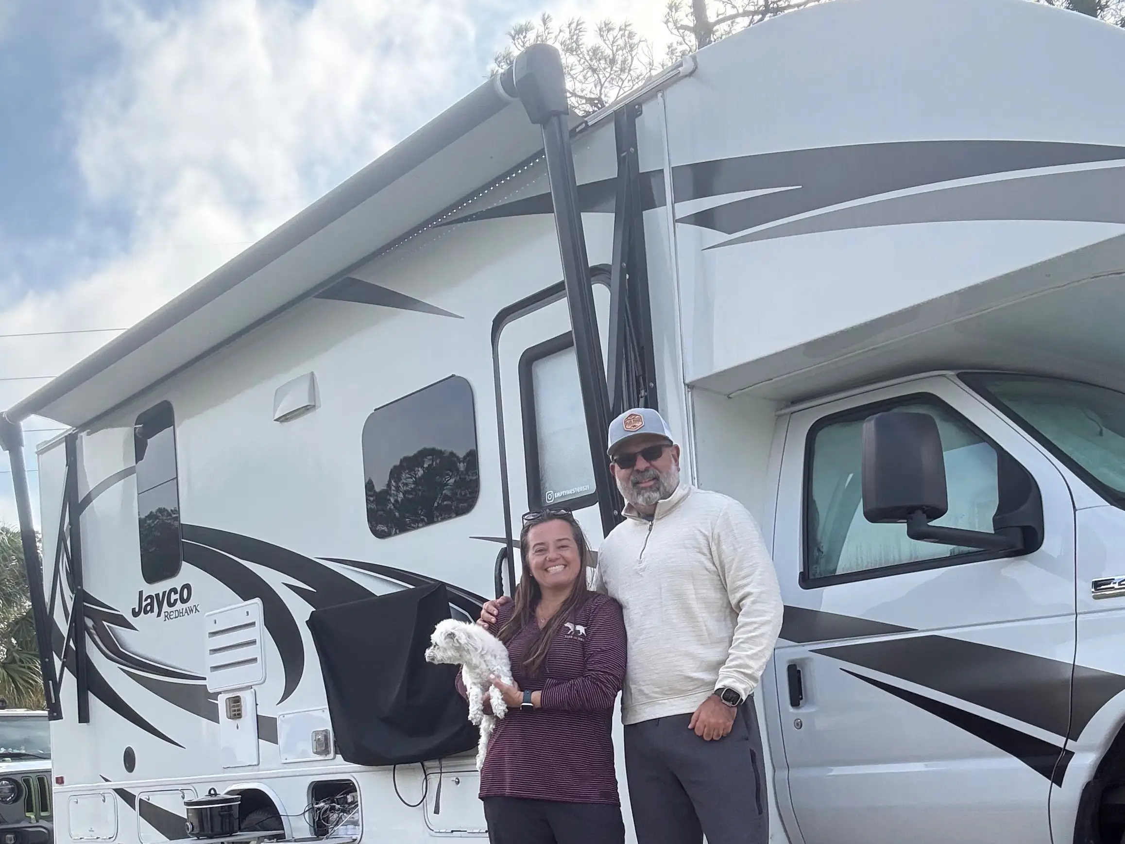 Courtney Bautista and her husband standing outside their RV