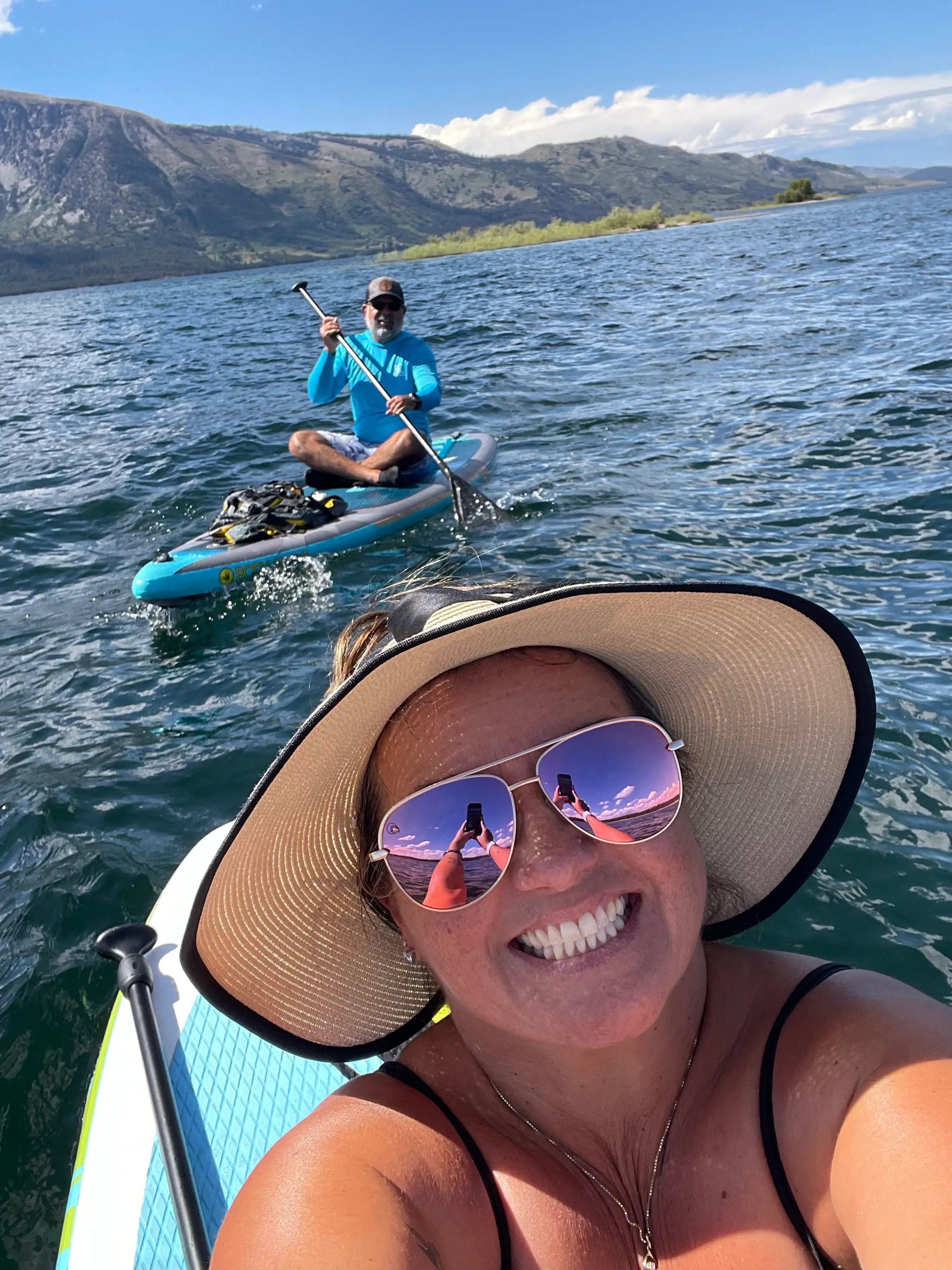 Courtney Bautista and her husband paddle boarding on the water