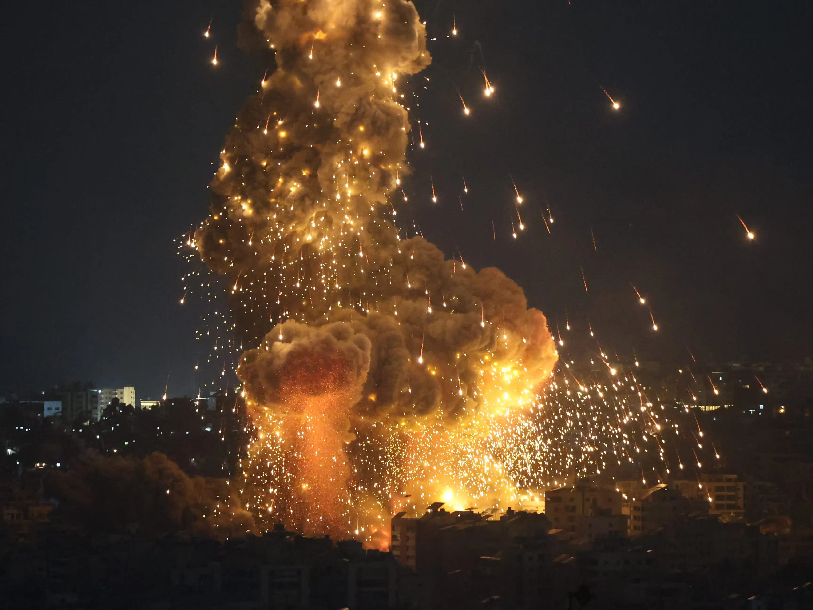 A massive explosion erupts over the Beirut skyline at night.