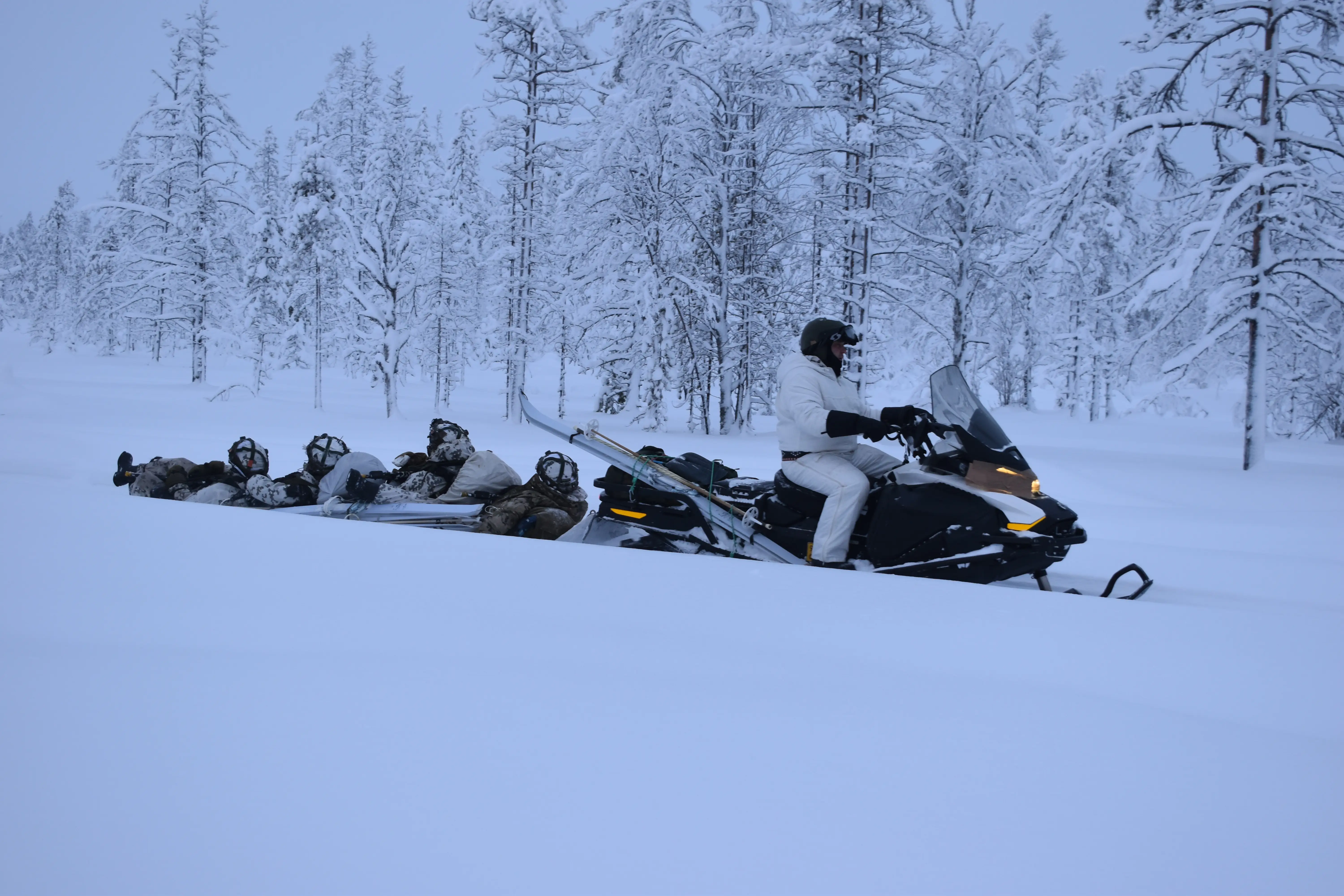 NATO soldiers are pulled by a snowmobile in northern Finland in January 2026.