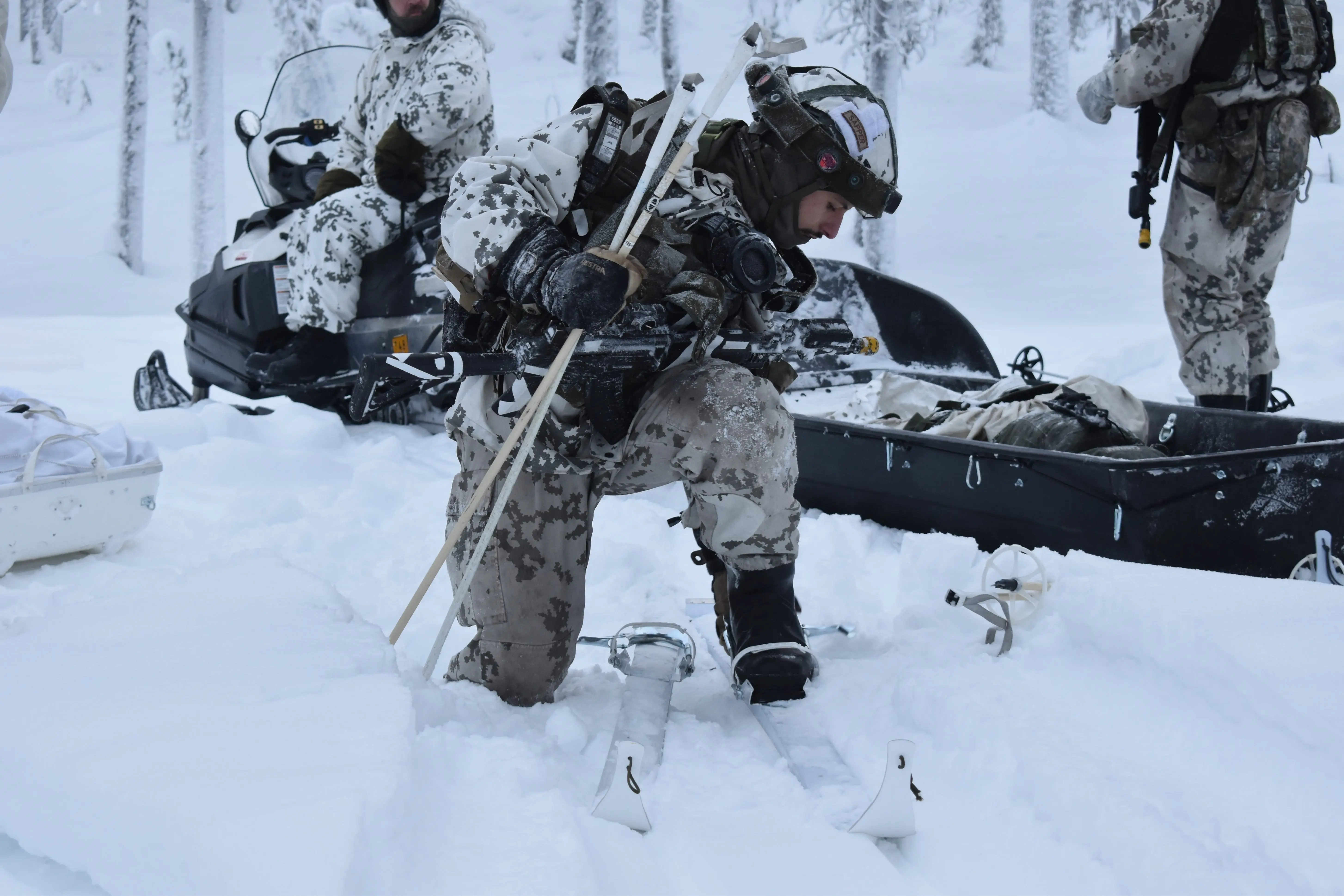 A NATO soldier straps into skis in northern Finland in January 2026.