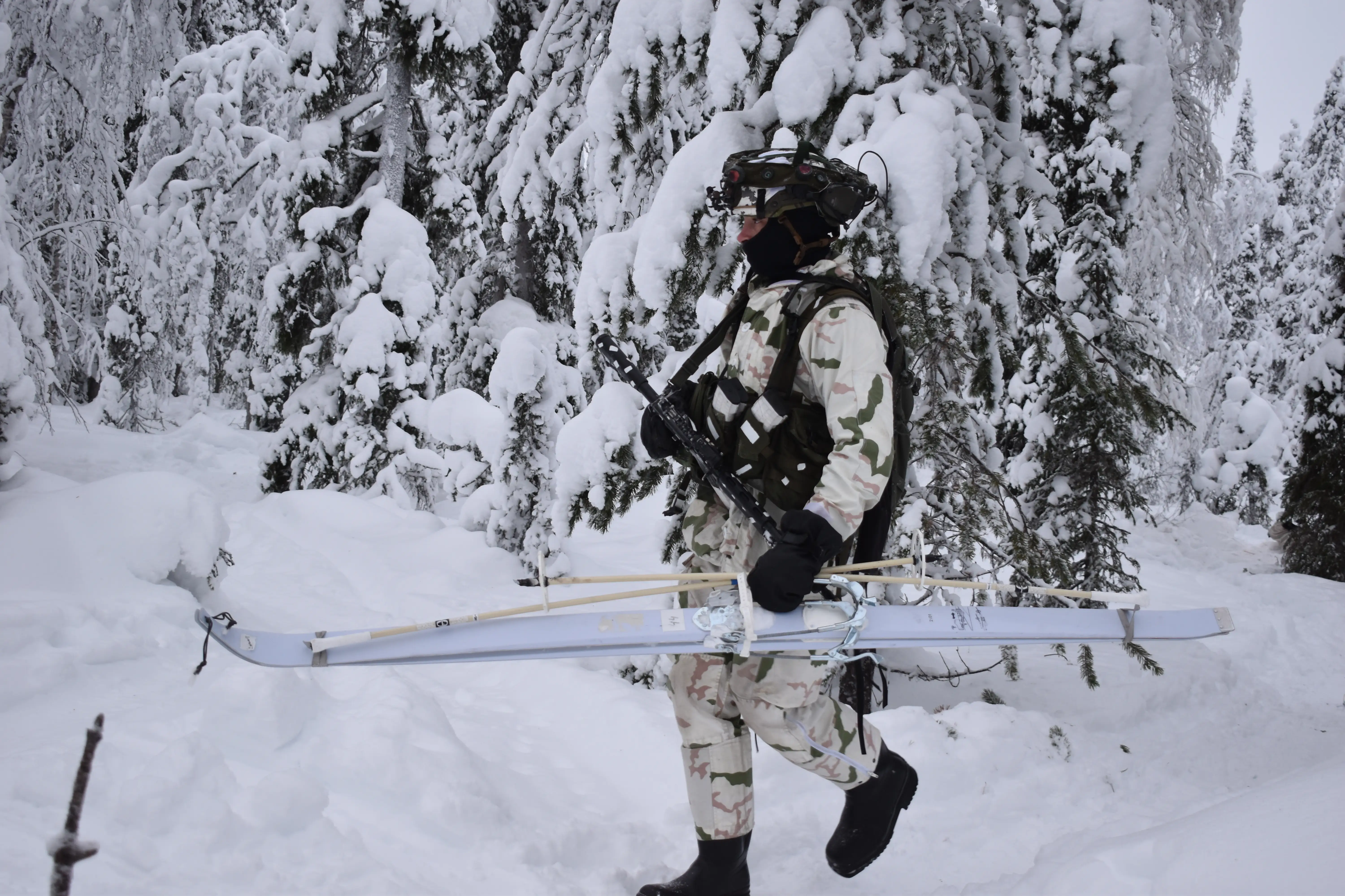 A NATO soldier carries his skis in northern Finland in January 2026.