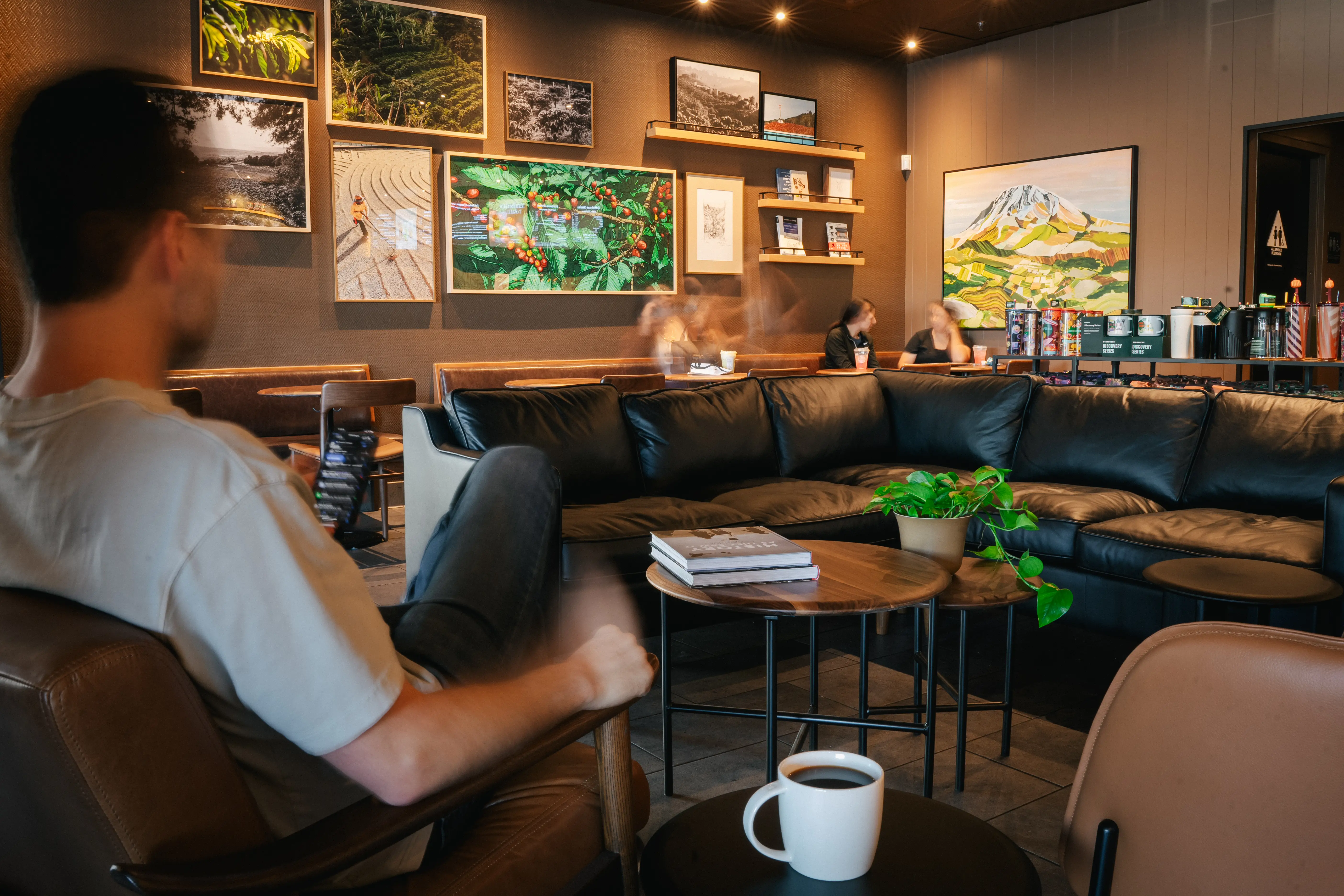 A customer sits in a plush chair inside a remodeled Starbucks coffeehouse.