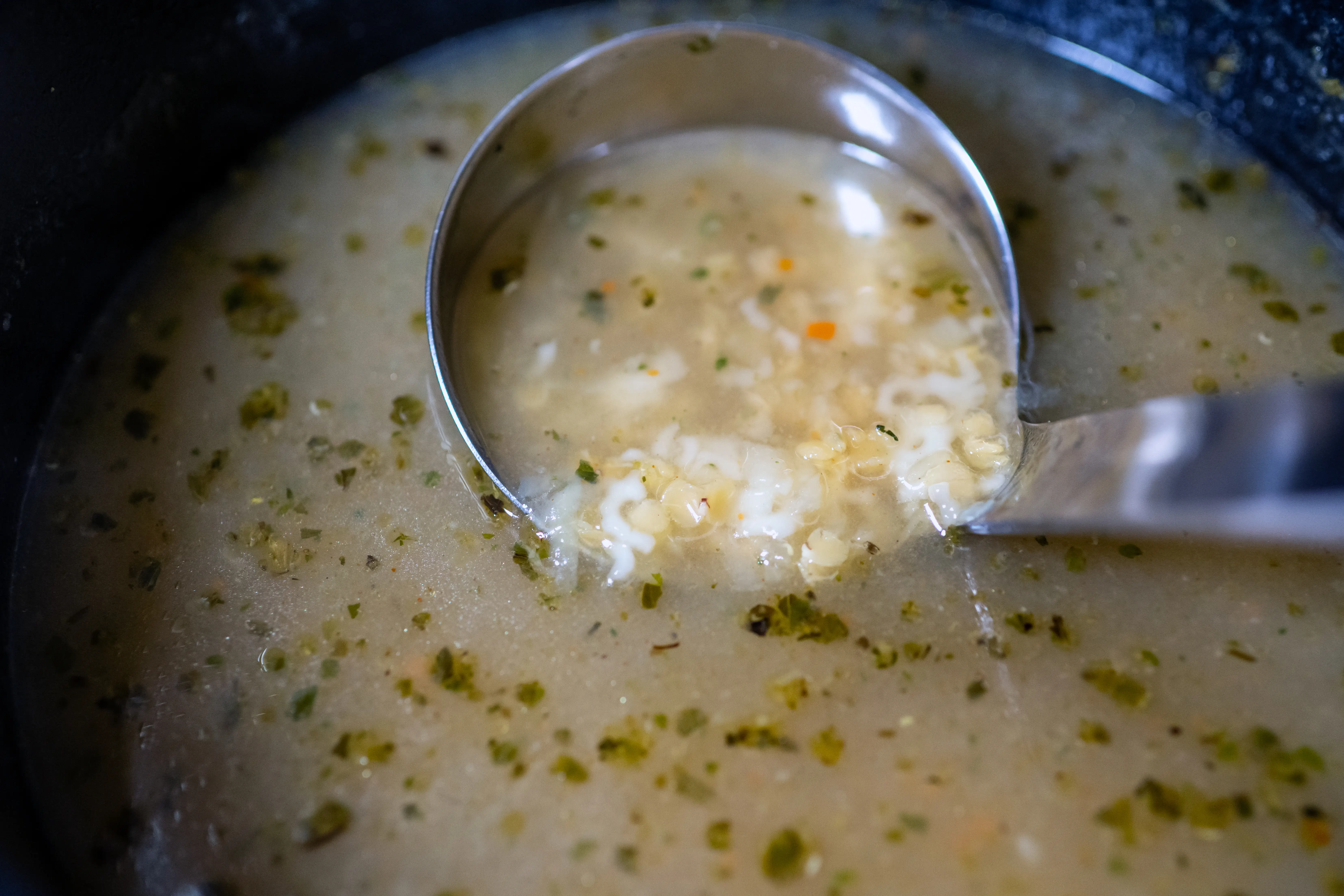 Soup with herbs in ladle