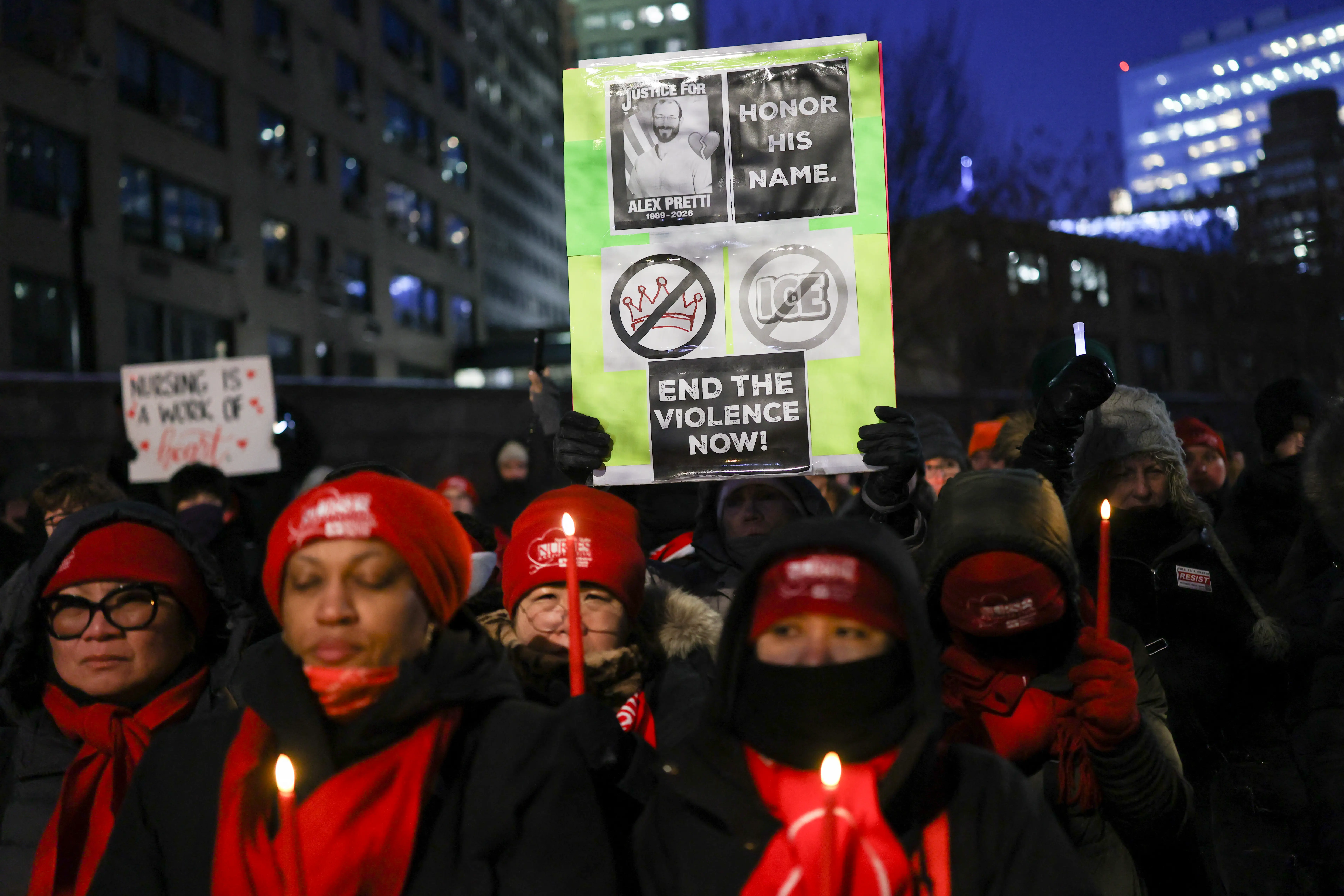 People hold signs and candles during a vigil for Alex Pretti, a 37-year-old nurse who was fatally shot by immigration agents in Minneapolis, at the Veterans Affairs NY Harbor Healthcare System Manhattan Campus in New York, on January 29, 2026.