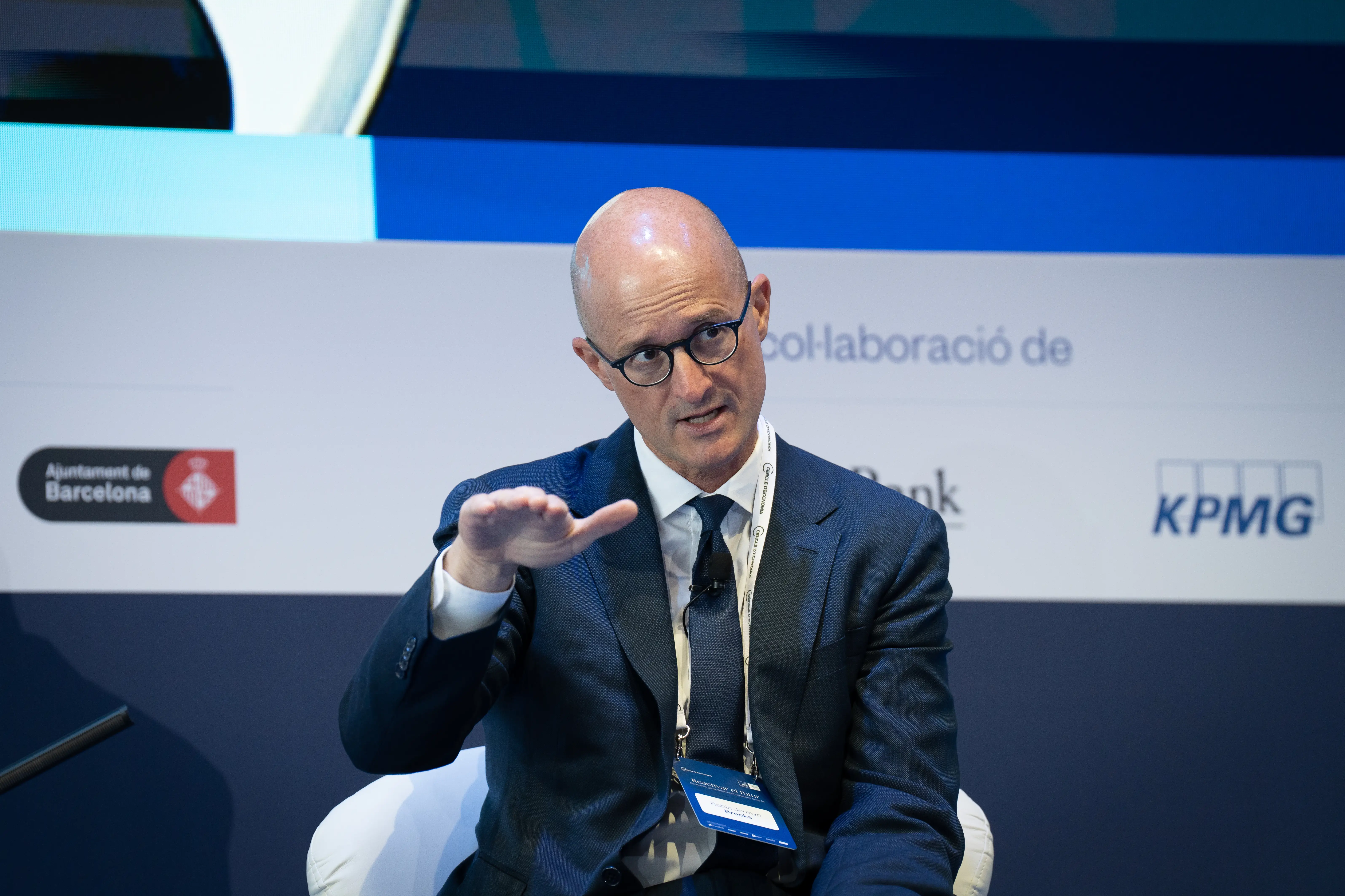 Robin Brooks, former Institute of International Finance chief economist and senior fellow at the Brookings Institution speaks on a panel against a blue backdrop.