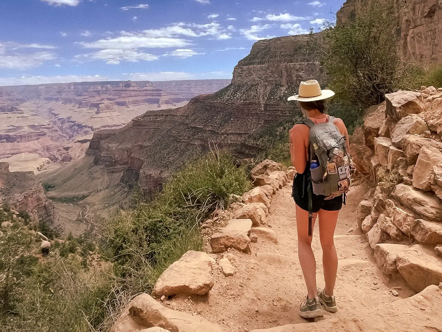 Emily walks along a trail on a sunny day in Grand Canyon National Park.