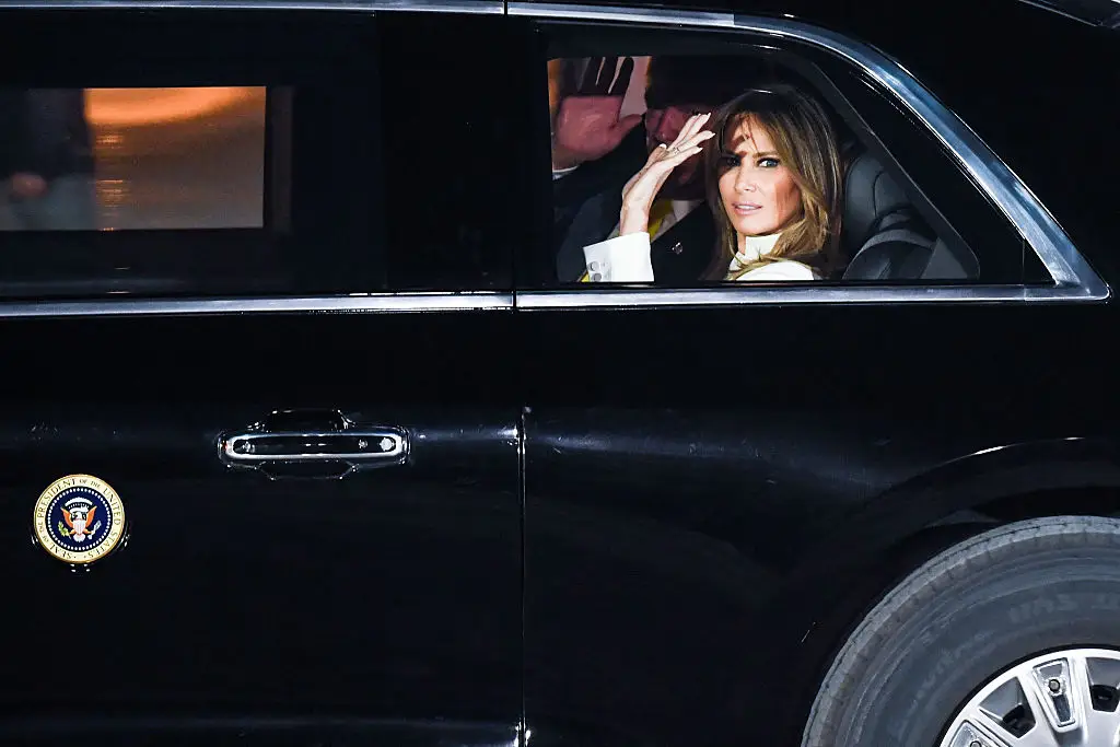 Melania Trump waves from a car.