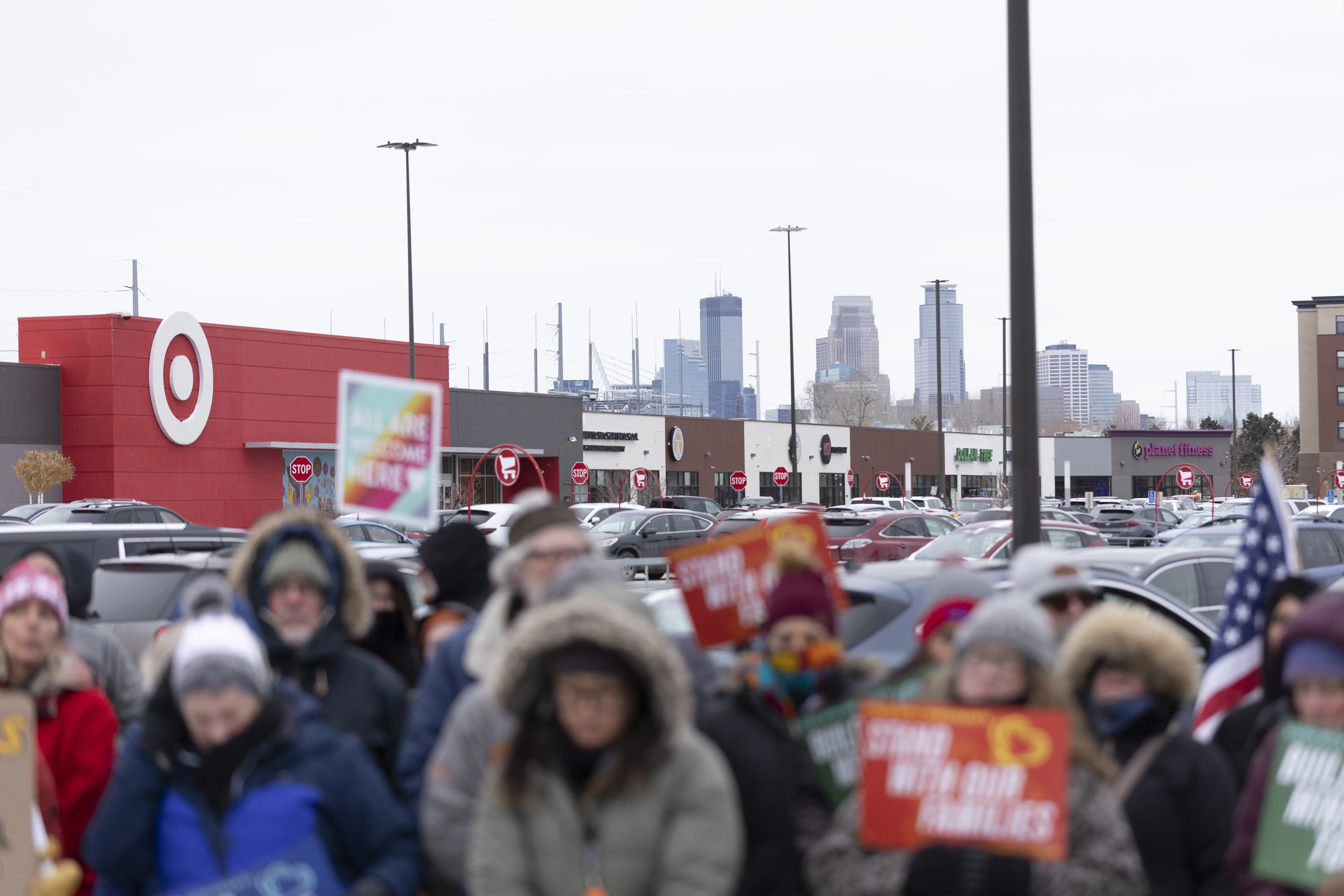 Community members hold banners as they show up to a press conference to demand accountability from Target after ICE agents were spotted staging at the parking lot in Minneapolis.