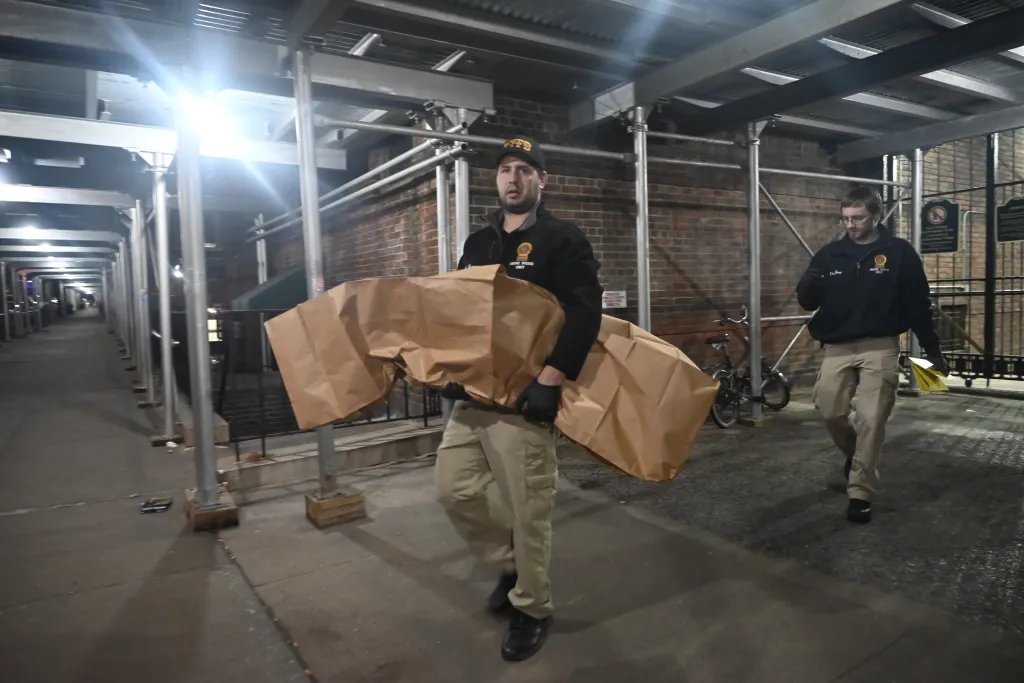 Members of the NYPD crime scene unit removing evidence from the scene where a 76-year-old woman was found dead with head and body trauma at 18 Monroe Street.