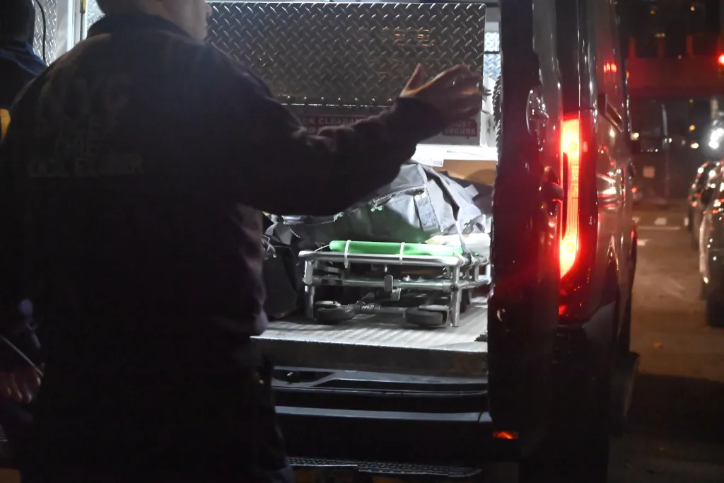 A member of the Office of the Chief Medical Examiner works at the scene where a 76-year-old woman was found dead with trauma.