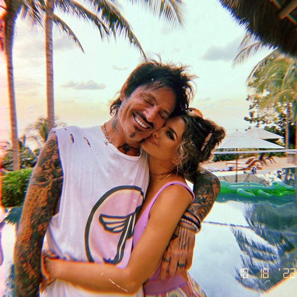 Tommy Lee embracing his wife, Brittany Furlan, outdoors.