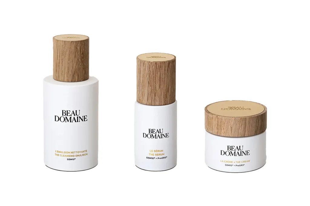 Three Beau Domaine skincare products: The Cleansing Emulsion, The Serum, and The Cream.