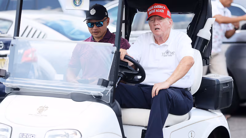Former President Donald Trump drives a golf cart accompanied by aide Walt Nauta prior to the start of day three of the LIV Golf Invitational - Bedminster at Trump National Golf Club on Aug. 13, 2023 in Bedminster, New Jersey.