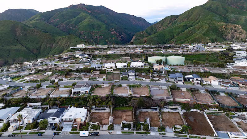 An aerial view shows empty lots and new homes under construction in Pacific Palisades, California on January 5, 2026. Altadena was hardest hit by the fires that ravaged parts of the sprawling US metropolis in January 2025. Thousands of homes were destroyed and 19 people died in the town -- compared to 12 killed in the upscale Pacific Palisades neighborhood. (Photo by JOSH EDELSON / AFP via Getty Images)