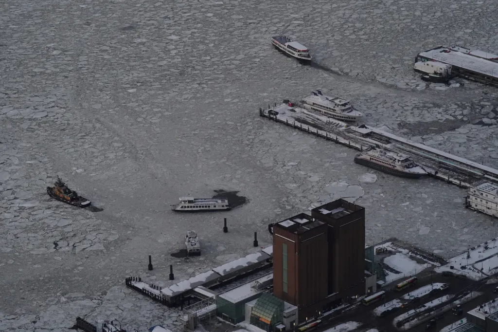 The Hudson River from the Edge at Hudson Yards, with several boats on the icy water and docks covered in snow.