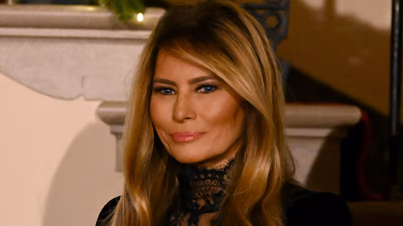 US First Lady Melania Trump looks on as President Donald Trump delivers remarks during the Congressional Ball in the Grand Foyer of the White House in Washington, DC, on December 11, 2025.