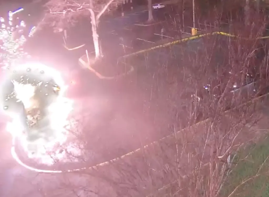 gunfire flashes in the darkness as the suspect opens fire before driving away, leaving the officer wounded inside the patrol car.