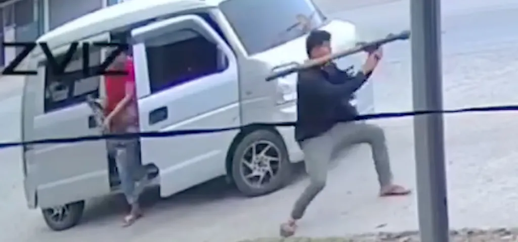 Two men with weapons standing next to a white van.