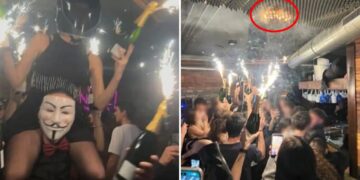 Haunting photo shows revelers waving flaming champagne bottles as Swiss nightclub roof catches fire