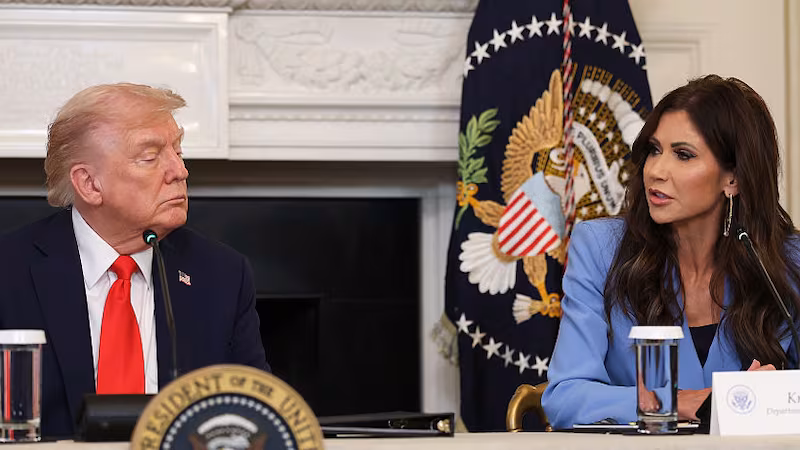 Secretary of Homeland Security Kristi Noem (R) speaks as U.S. President Donald Trump listens during a roundtable discussion in the State Dining Room of the White House on October 08, 2025 in Washington, DC. Trump’s administration held the roundtable to discuss the anti-fascist Antifa movement after signing an executive order designating it as a “domestic terrorist organization”.
