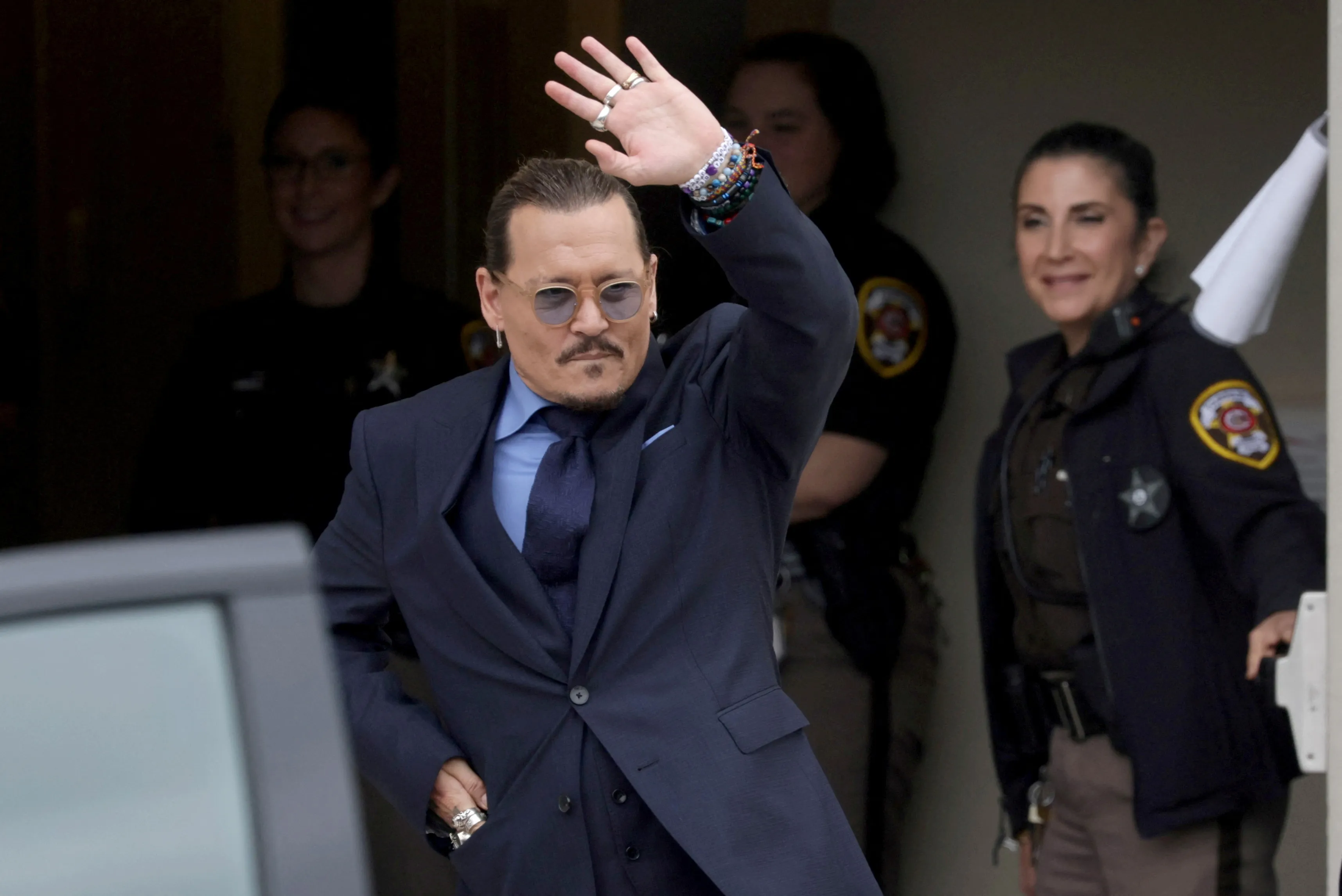 Johnny Depp waves to the crowd while leaving the courthouse after his defamation trial against his ex-wife Amber Heard.