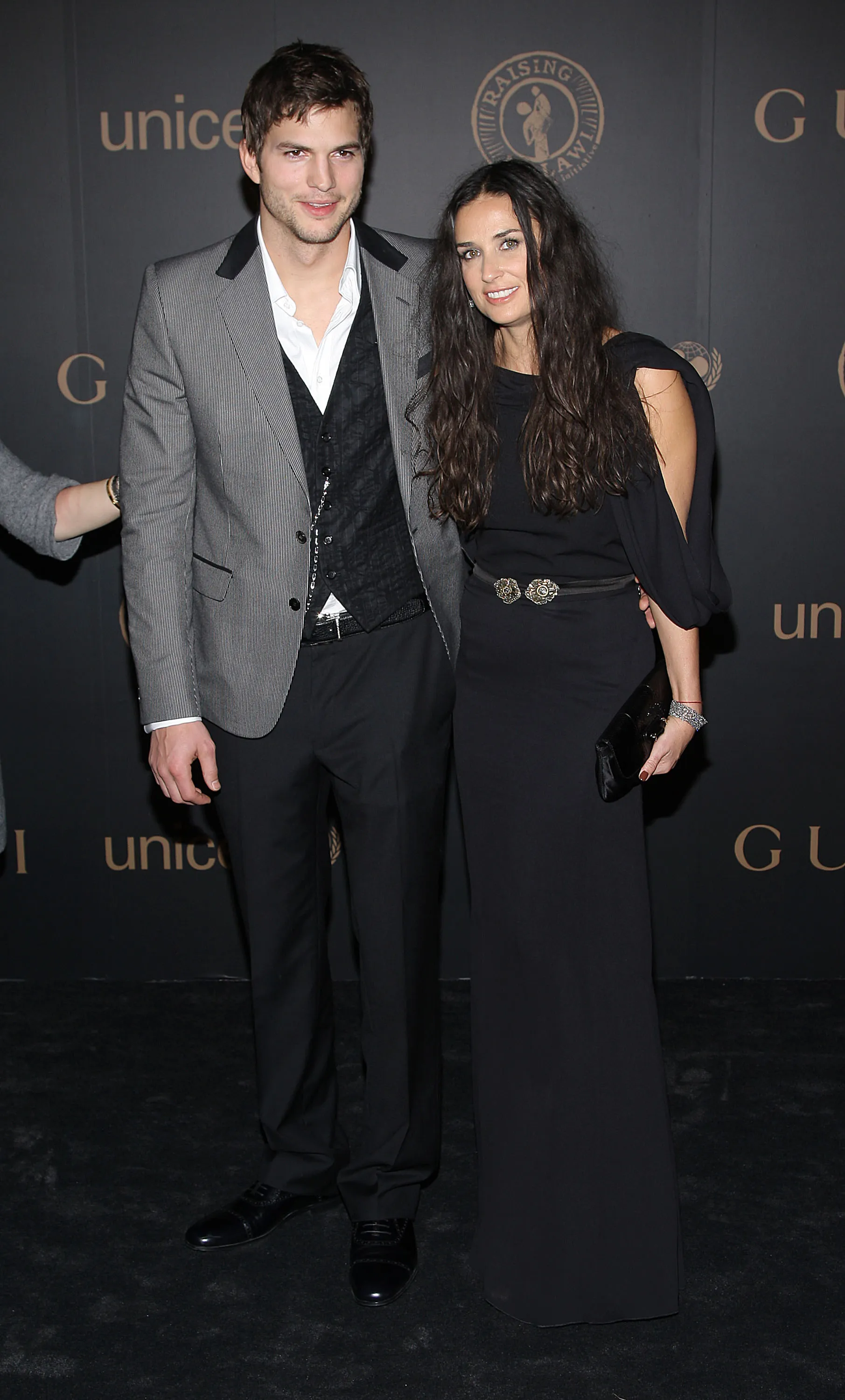 Actors Ashton Kutcher and Demi Moore posing at a reception to benefit UNICEF.