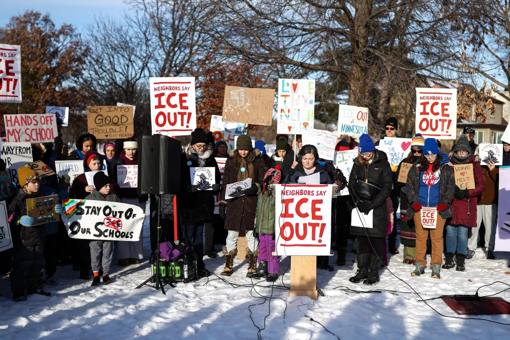 Protesters hold signs that say 