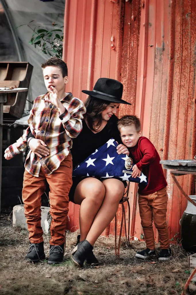 Alex Maddox with her two sons and a folded American flag.